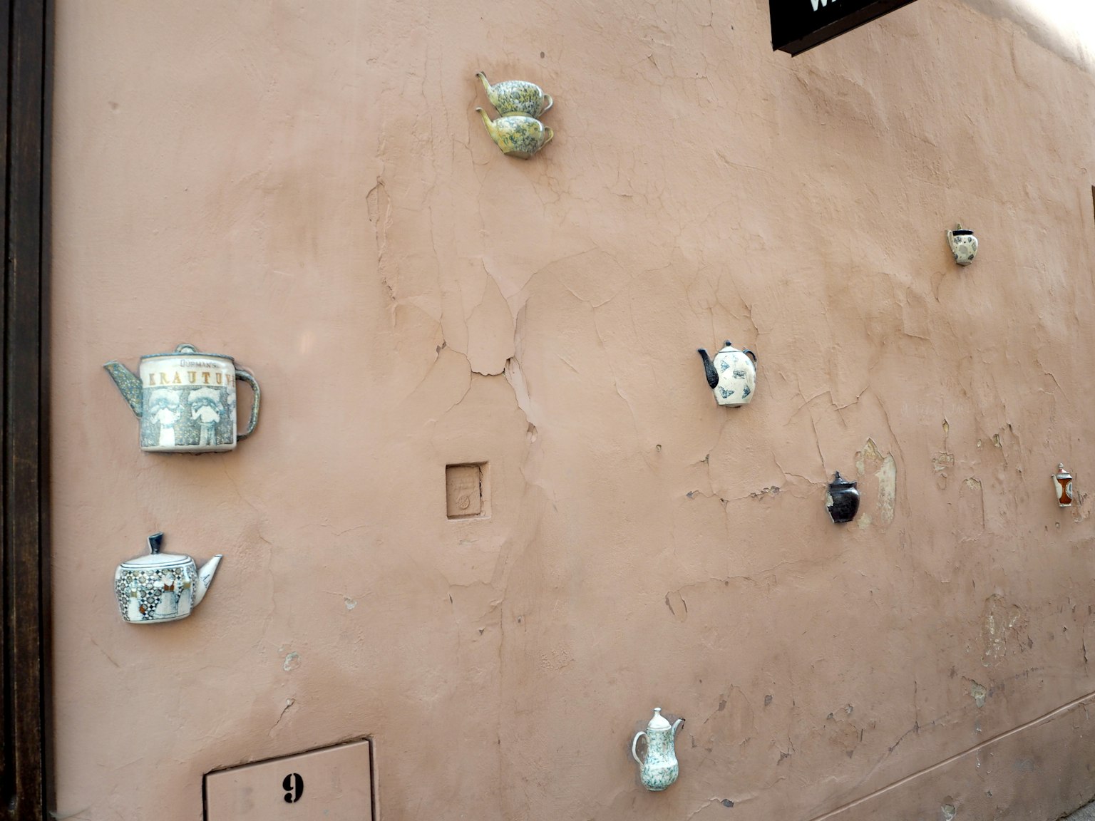 Installation artistique de théières fixées à un mur
