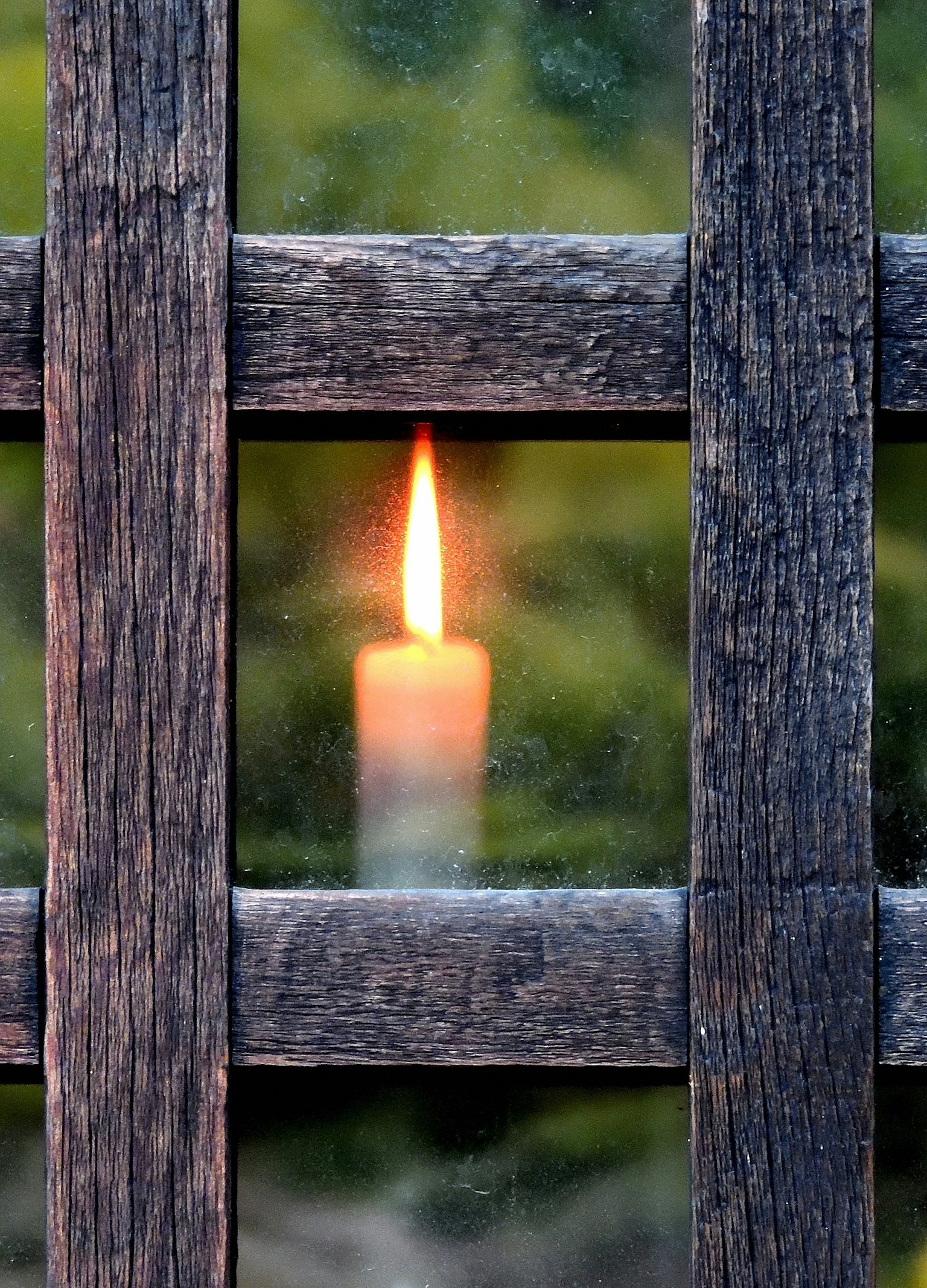 木製の格子の間から見えるキャンドルの炎