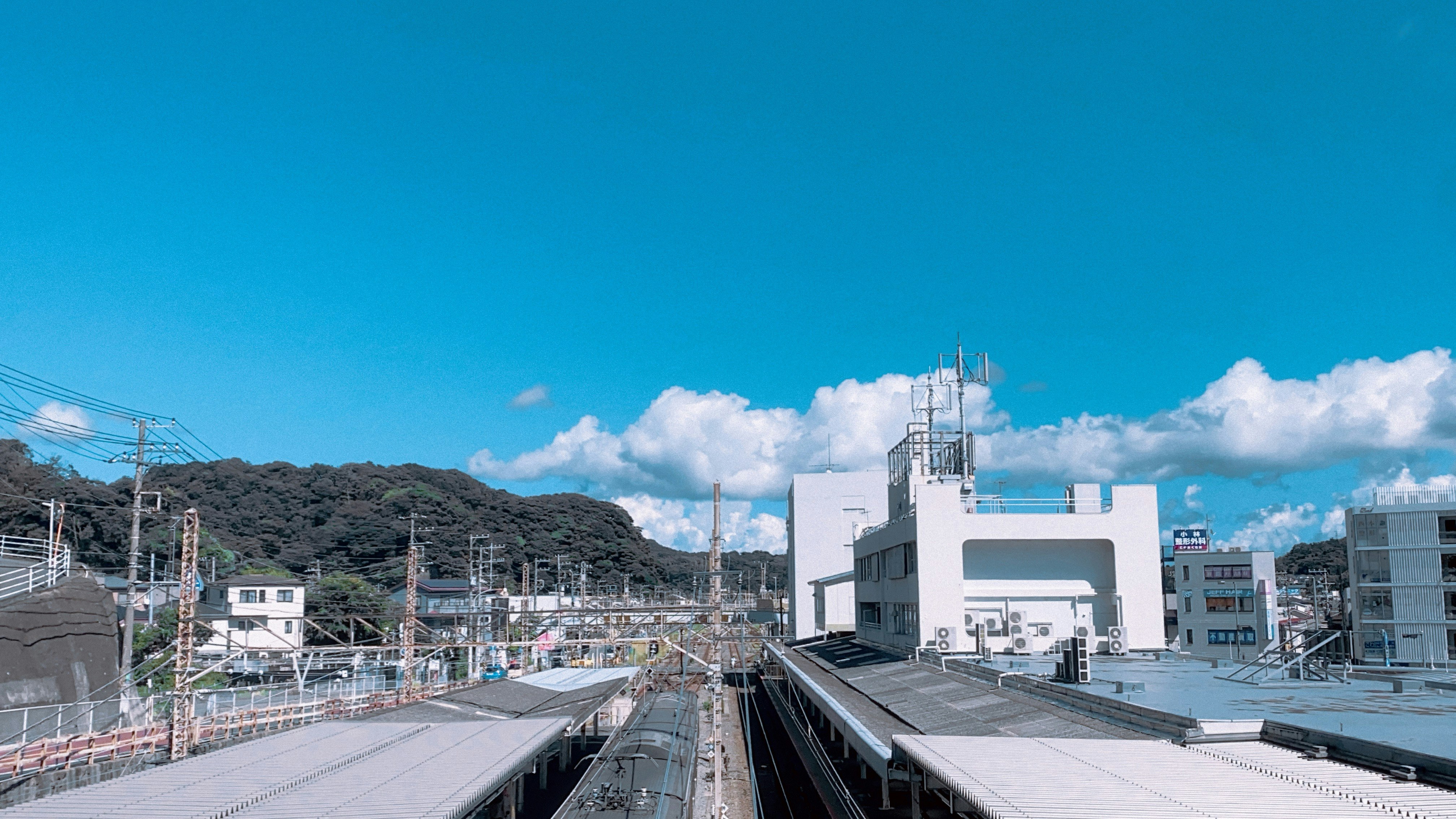 山あいの送電線と変電設備が並ぶ工業エリアの風景