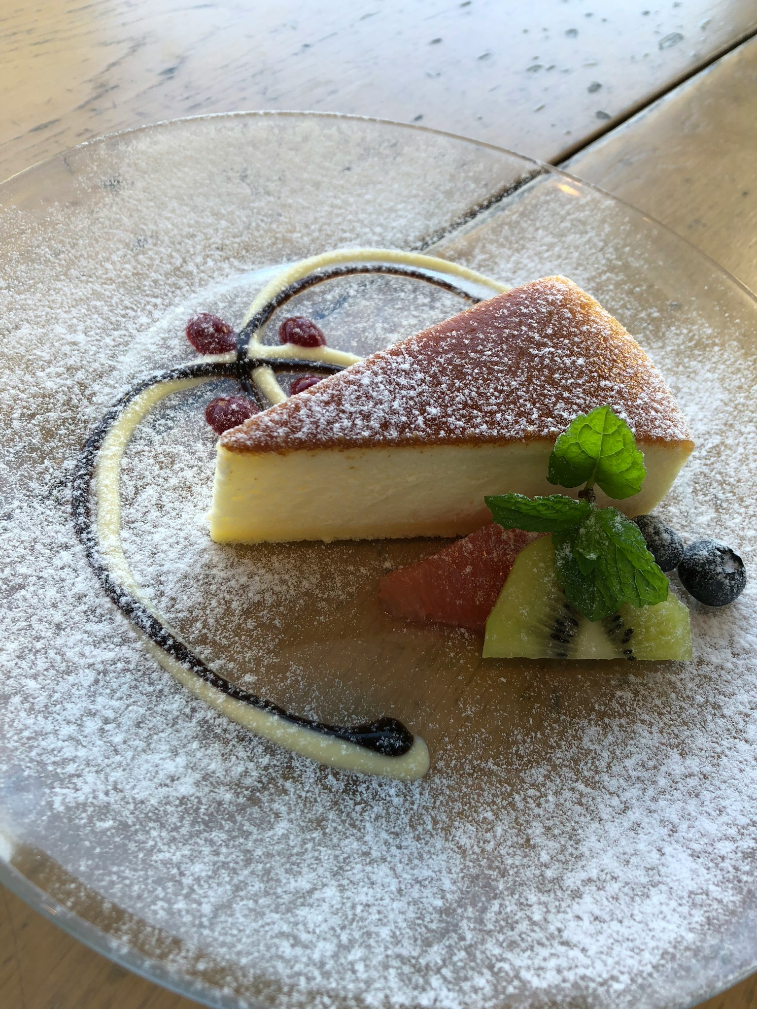 Cheesecake cremoso guarnito con menta e bacche su un piatto decorativo