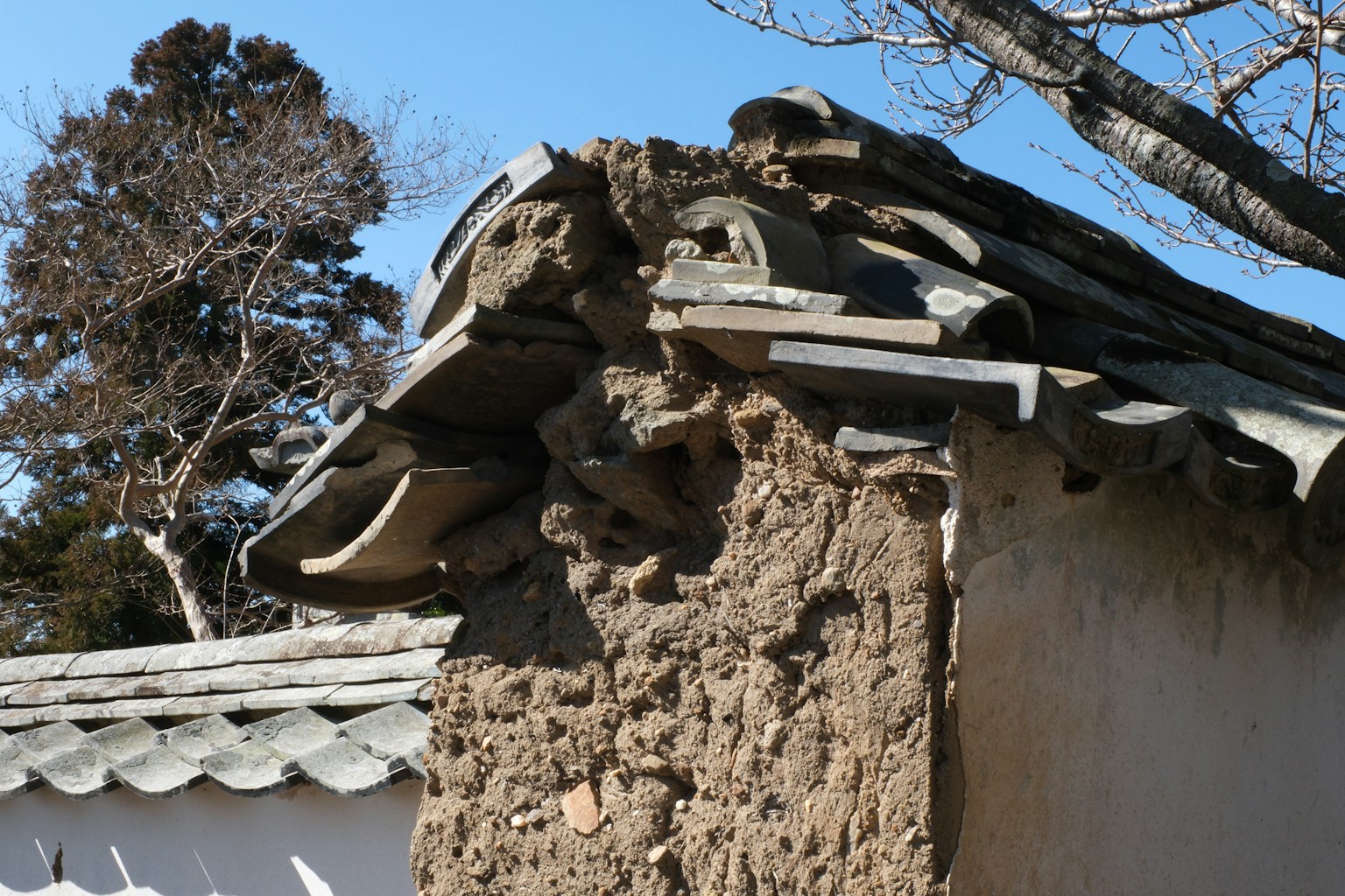 Traditional Japanese architecture featuring earthen wall and tiled roof