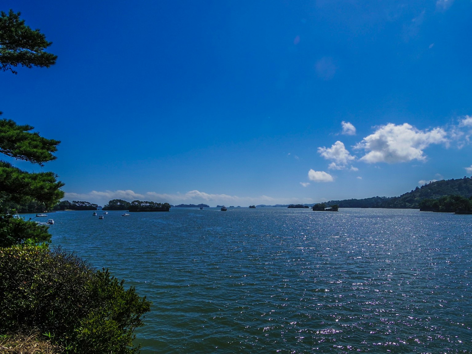Vista panoramica di un cielo blu e acqua scintillante con mare tranquillo e isole sparse che mostrano la bellezza naturale