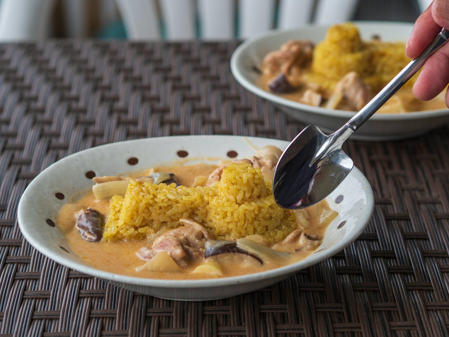 Un piatto con couscous giallo e pollo in salsa di curry cremosa