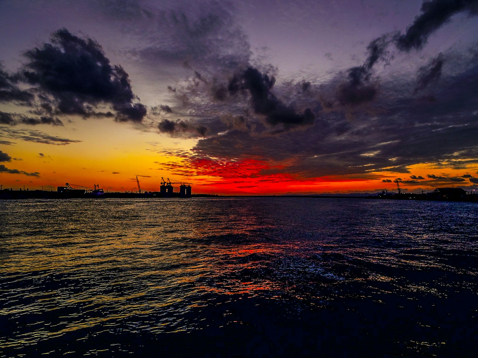 Lebhafter Sonnenuntergang über dem Ozean mit dramatischen Wolken