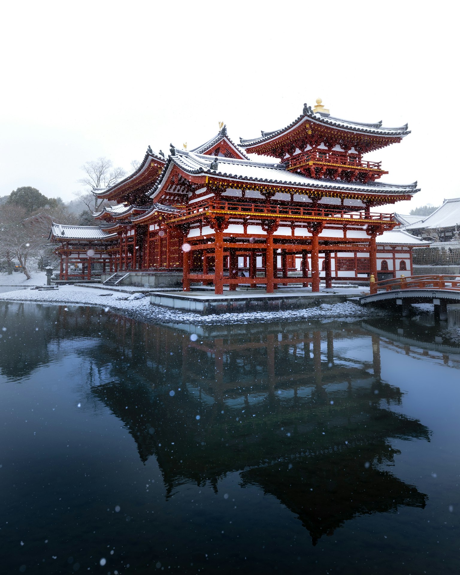 被雪覆蓋的傳統日本建築和寧靜的池塘