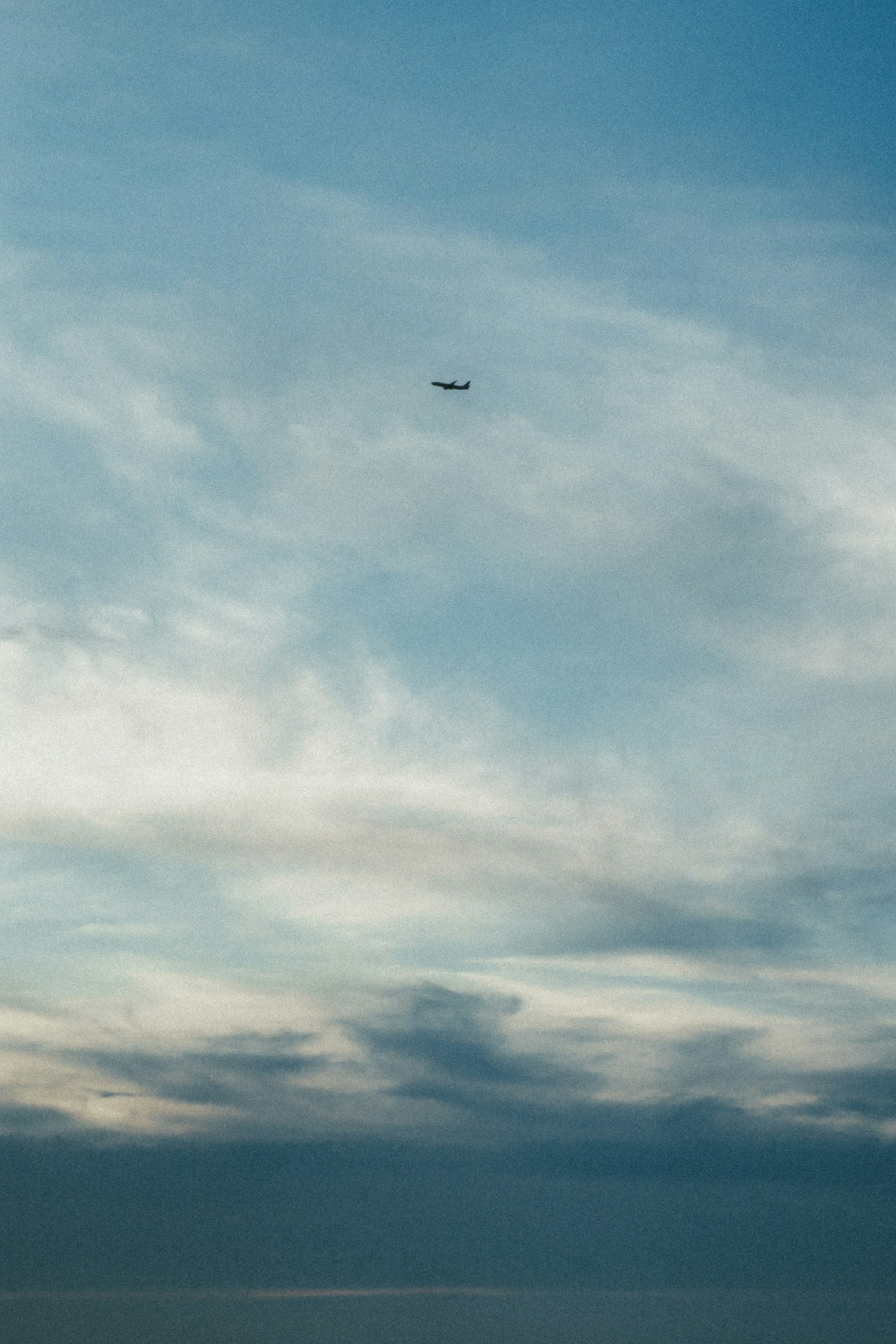 Ein Flugzeug fliegt in einem blauen Himmel mit Wolken