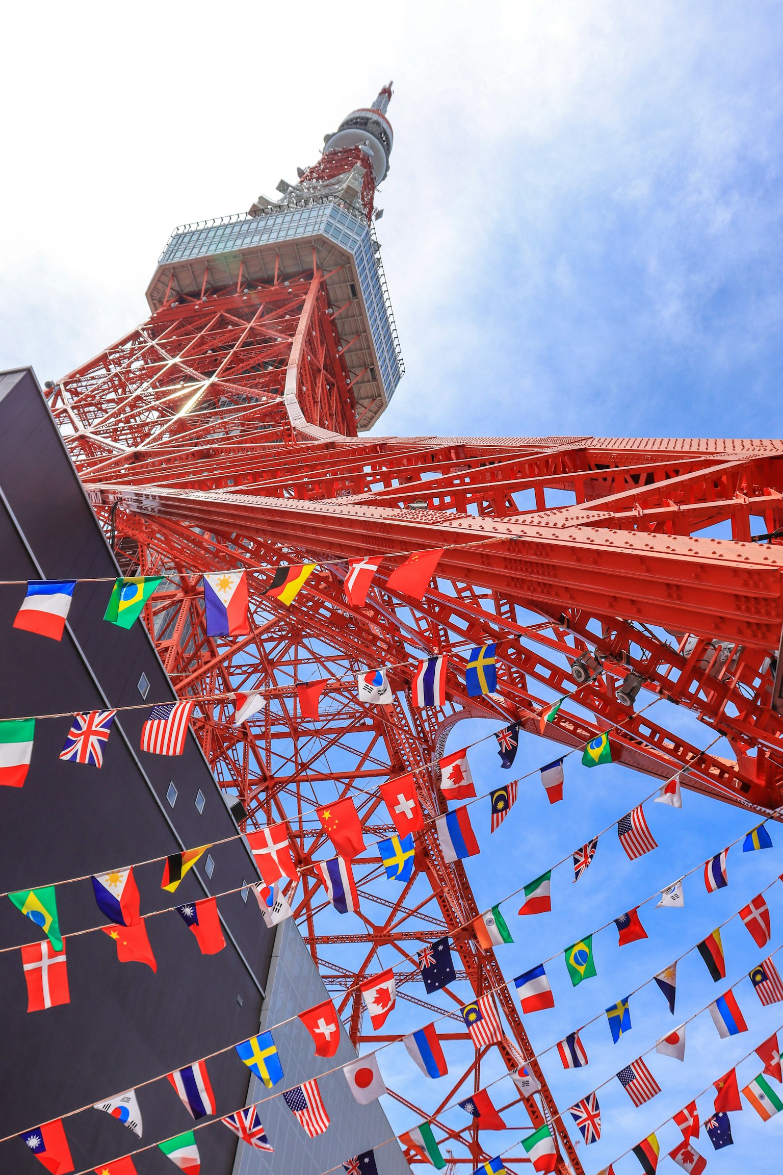 Tokyo Tower with vibrant red structure and numerous flags