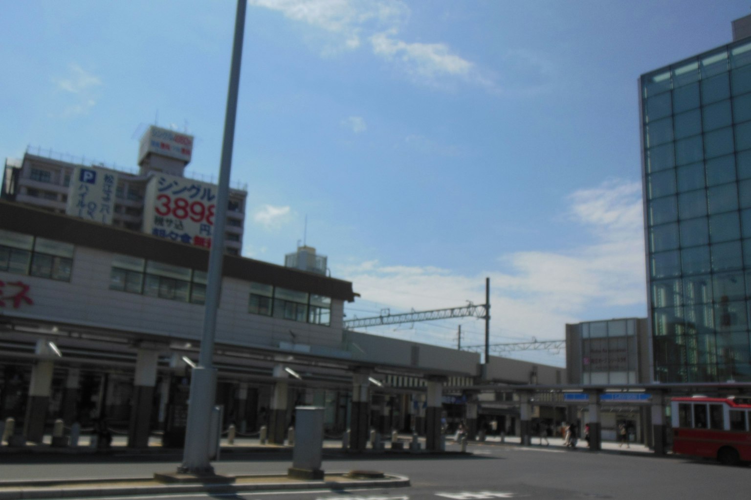 Esterno di una stazione ferroviaria sotto un cielo blu con un edificio moderno