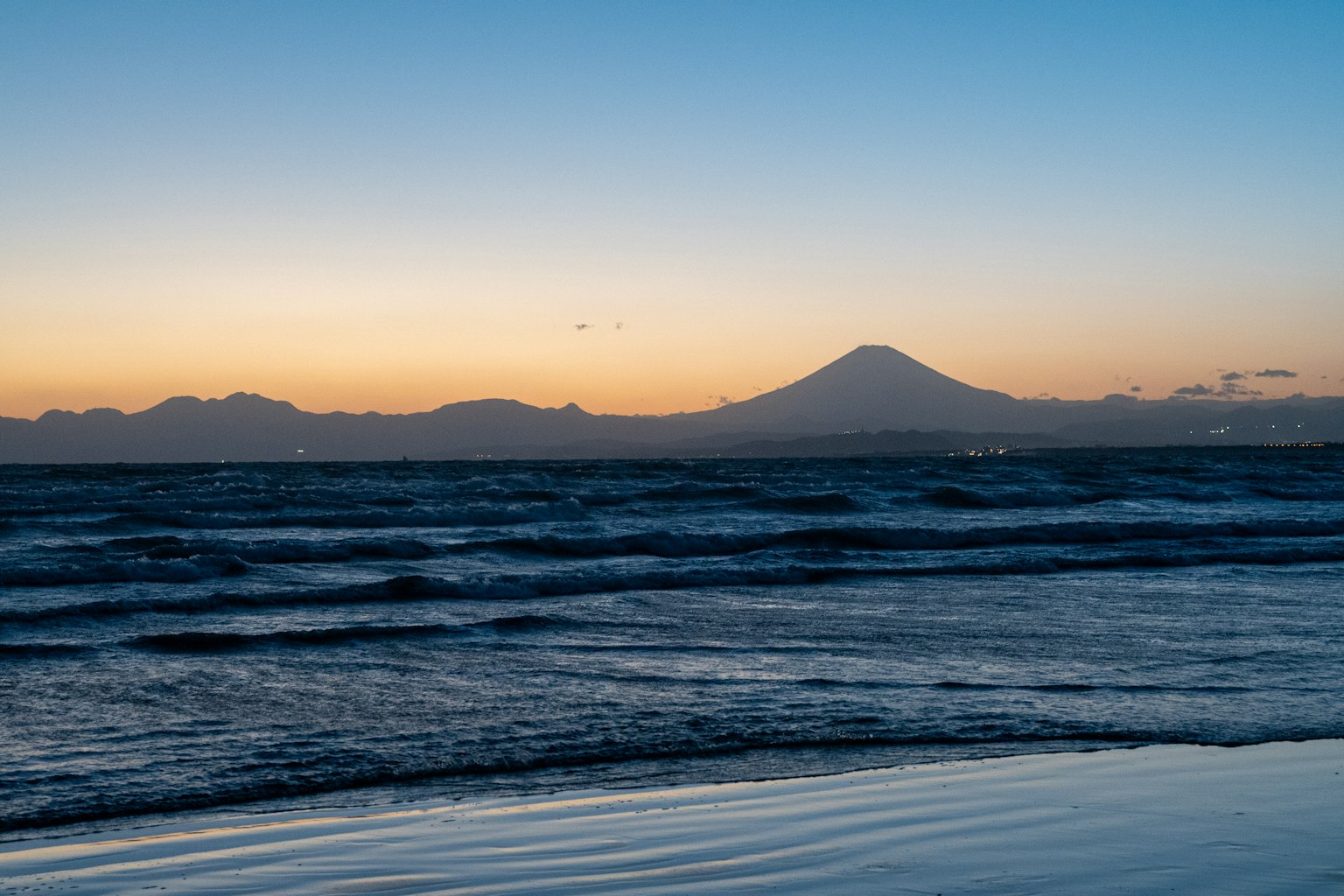 Pemandangan matahari terbenam yang indah dengan laut dan gunung