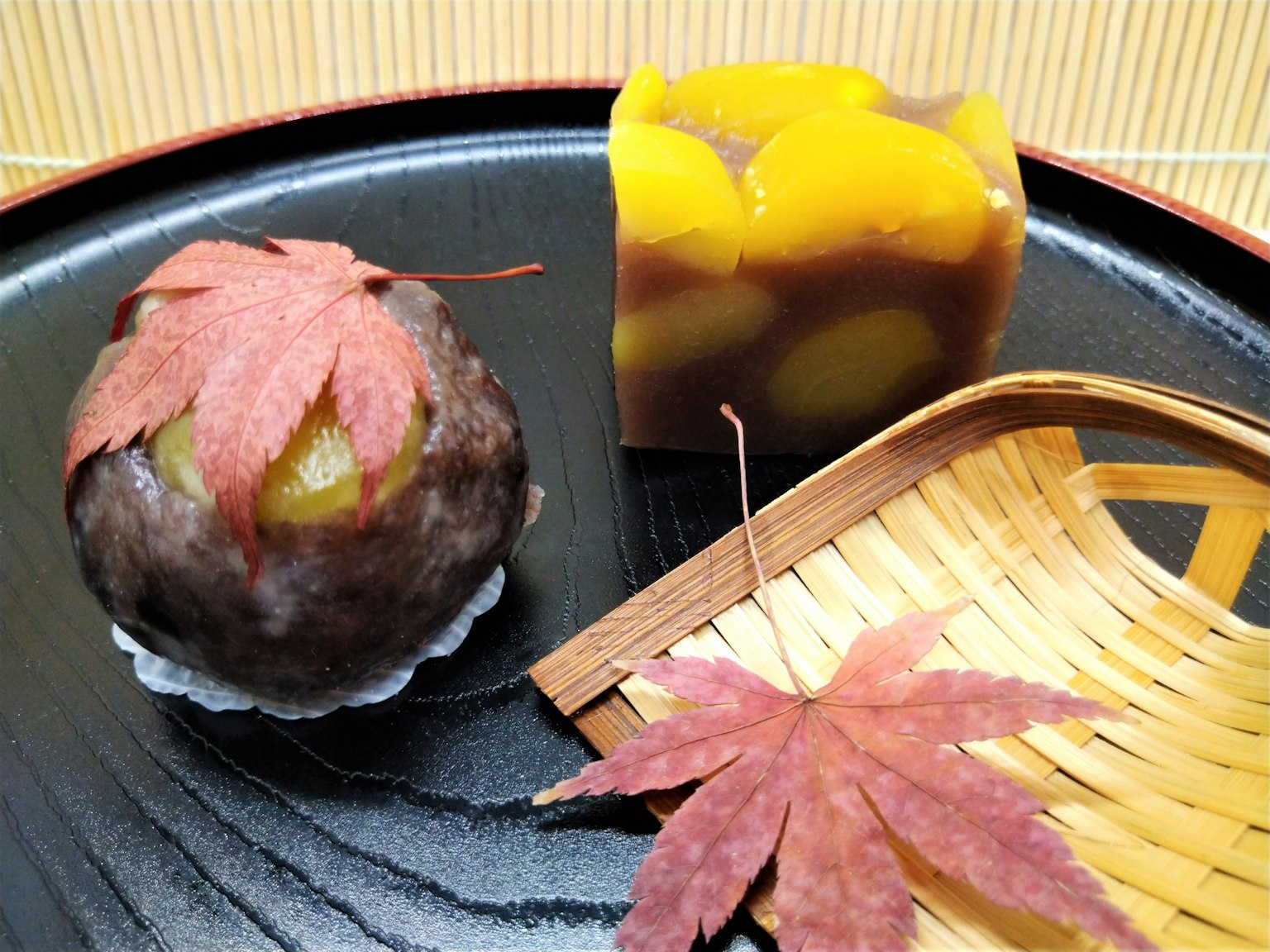 Herbstliche japanische Süßigkeitenanordnung mit Ahornblättern