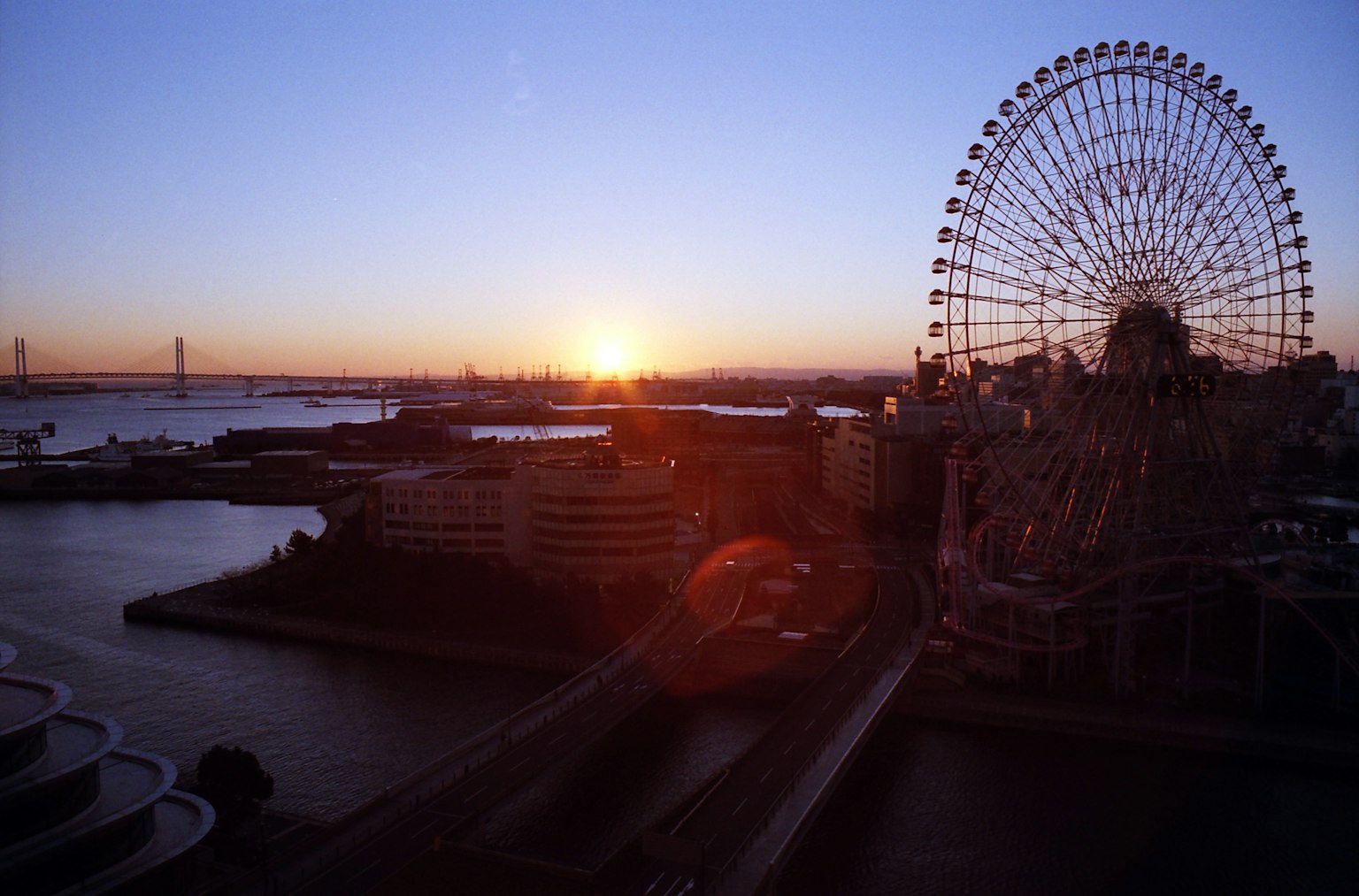 Ferris wheel and harbor view with sunset in the background