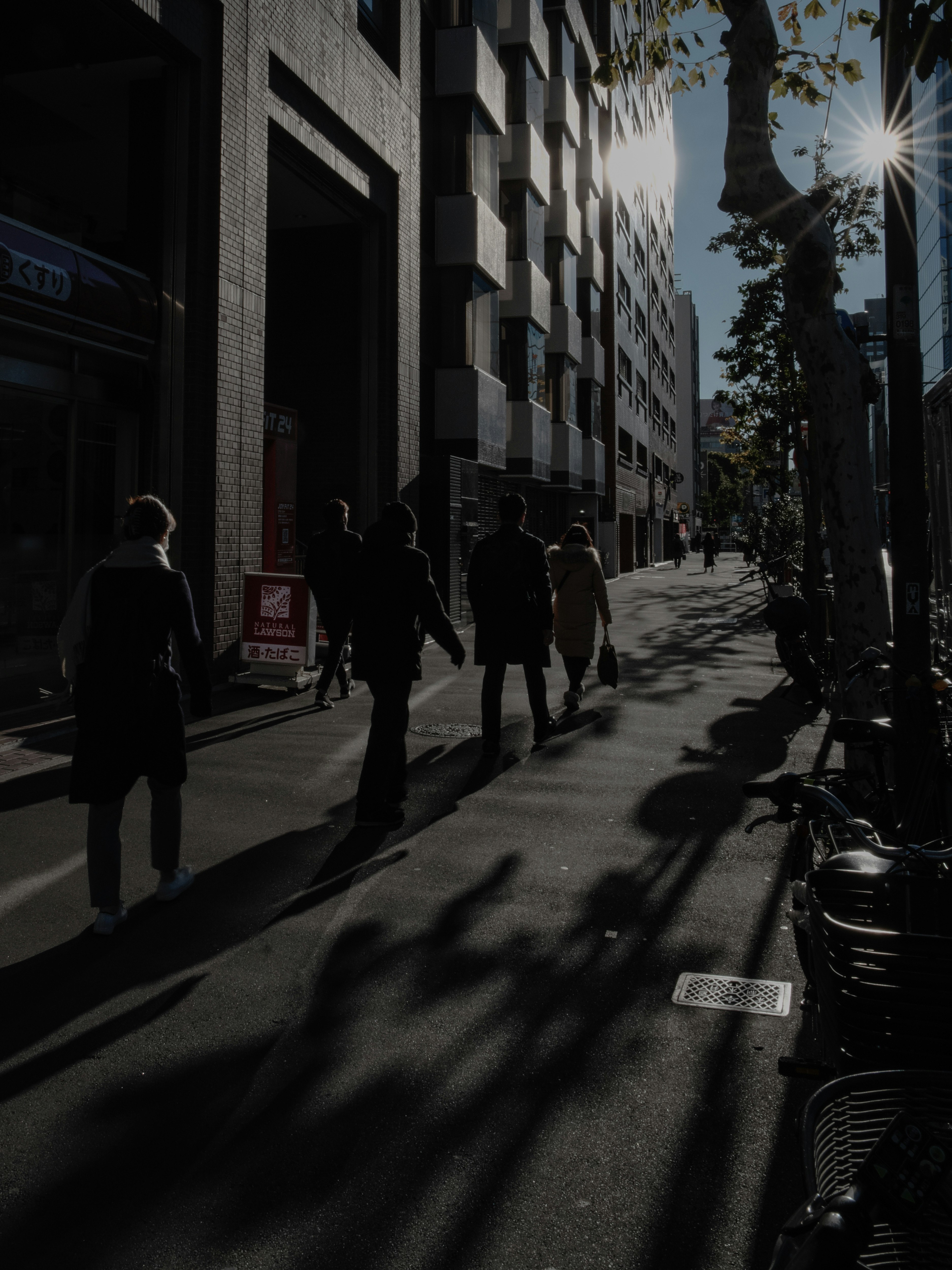 朝日に向かって歩く人々の街並み