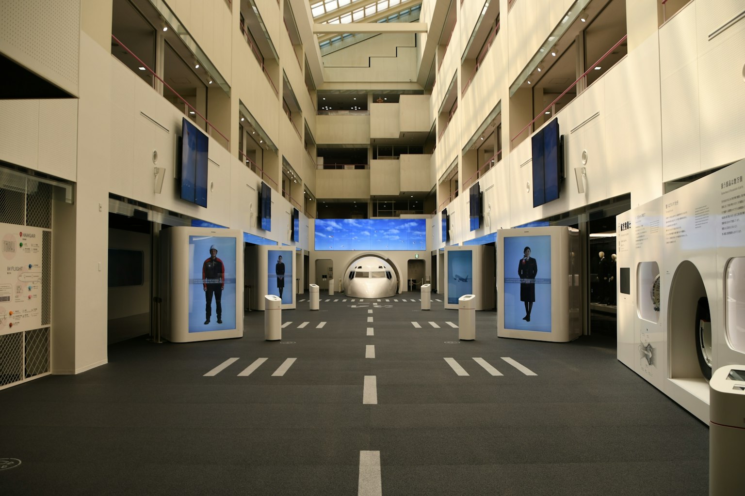 Spacious exhibition hall featuring blue screens and displays