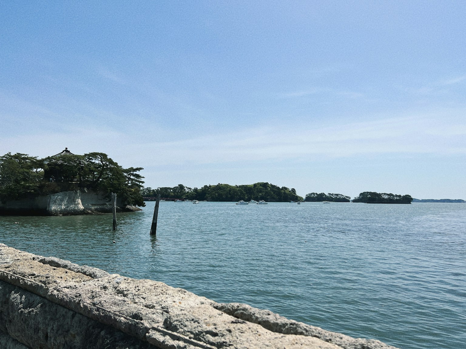 ทิวทัศน์ที่เงียบสงบของเกาะเล็กๆ และท่าเทียบเรือที่ล้อมรอบด้วยน้ำสงบและท้องฟ้าสีฟ้า
