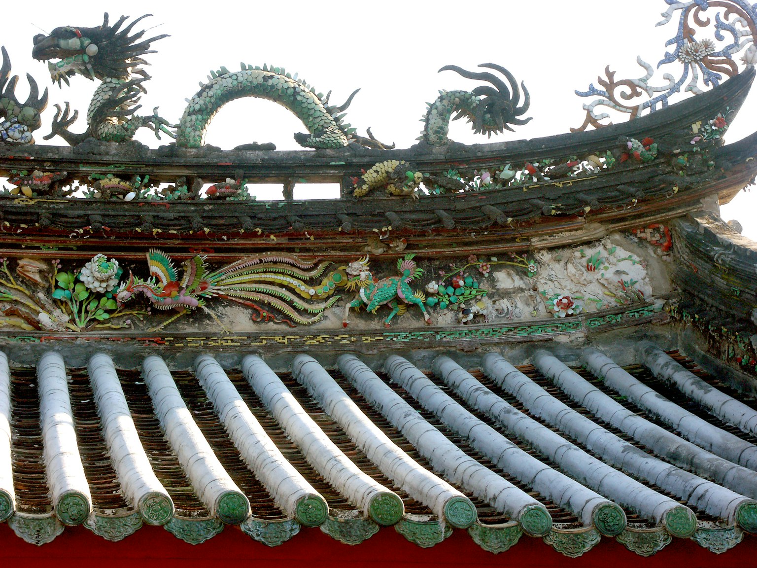 传统中国建筑，屋顶上有装饰性的龙雕塑和色彩丰富的图案