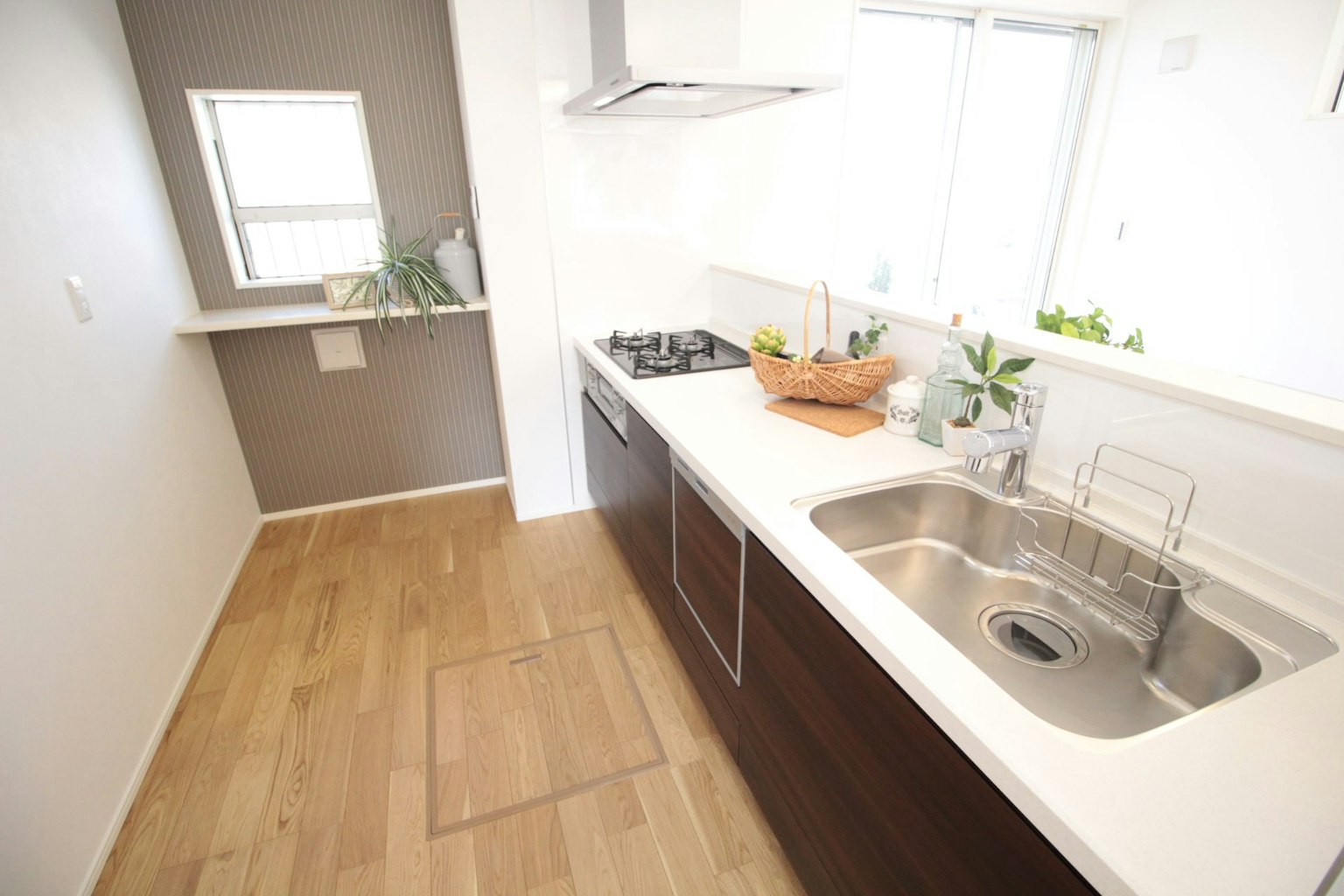 Bright modern kitchen with simple design featuring wooden floor and white countertop