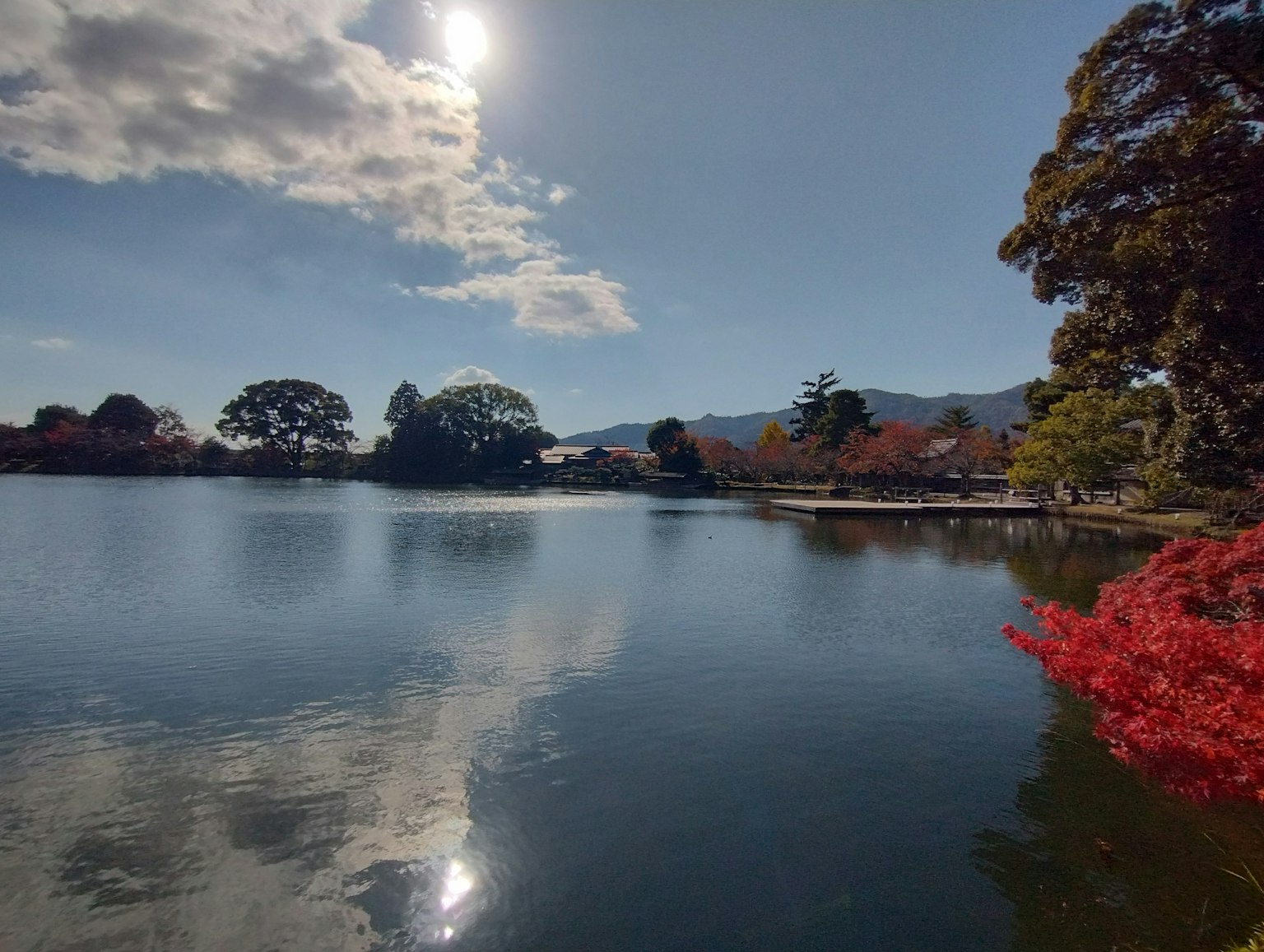 平靜的湖面映襯著秋天的樹葉和藍天
