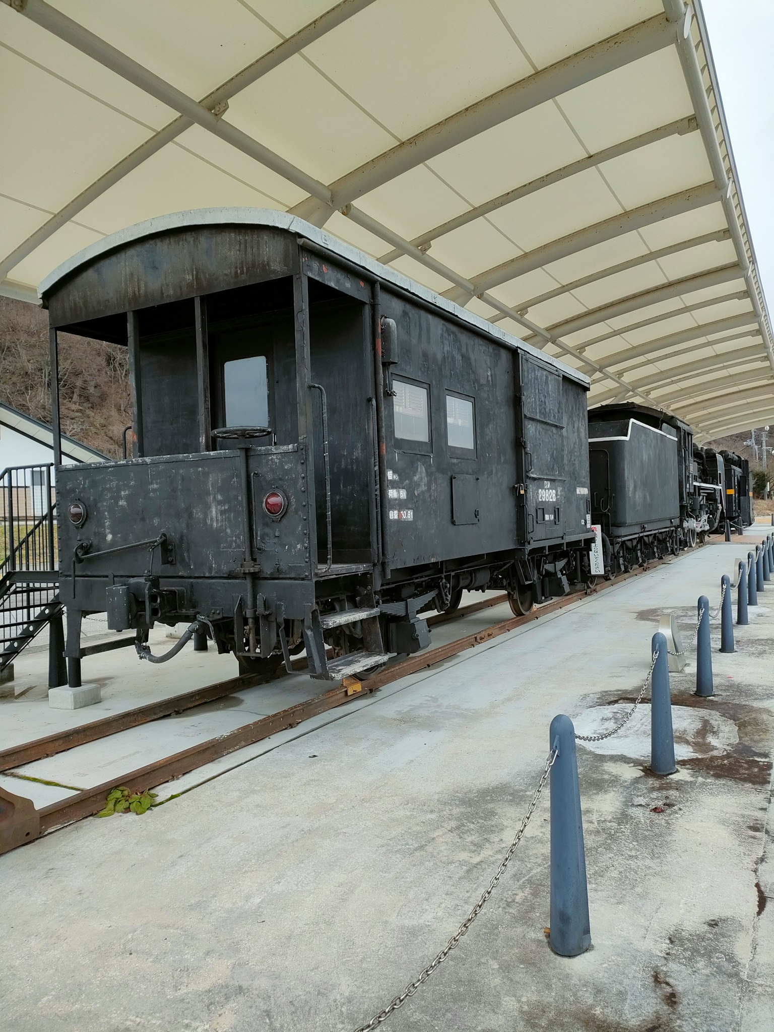 Un ancien wagon de fret noir garé à une station