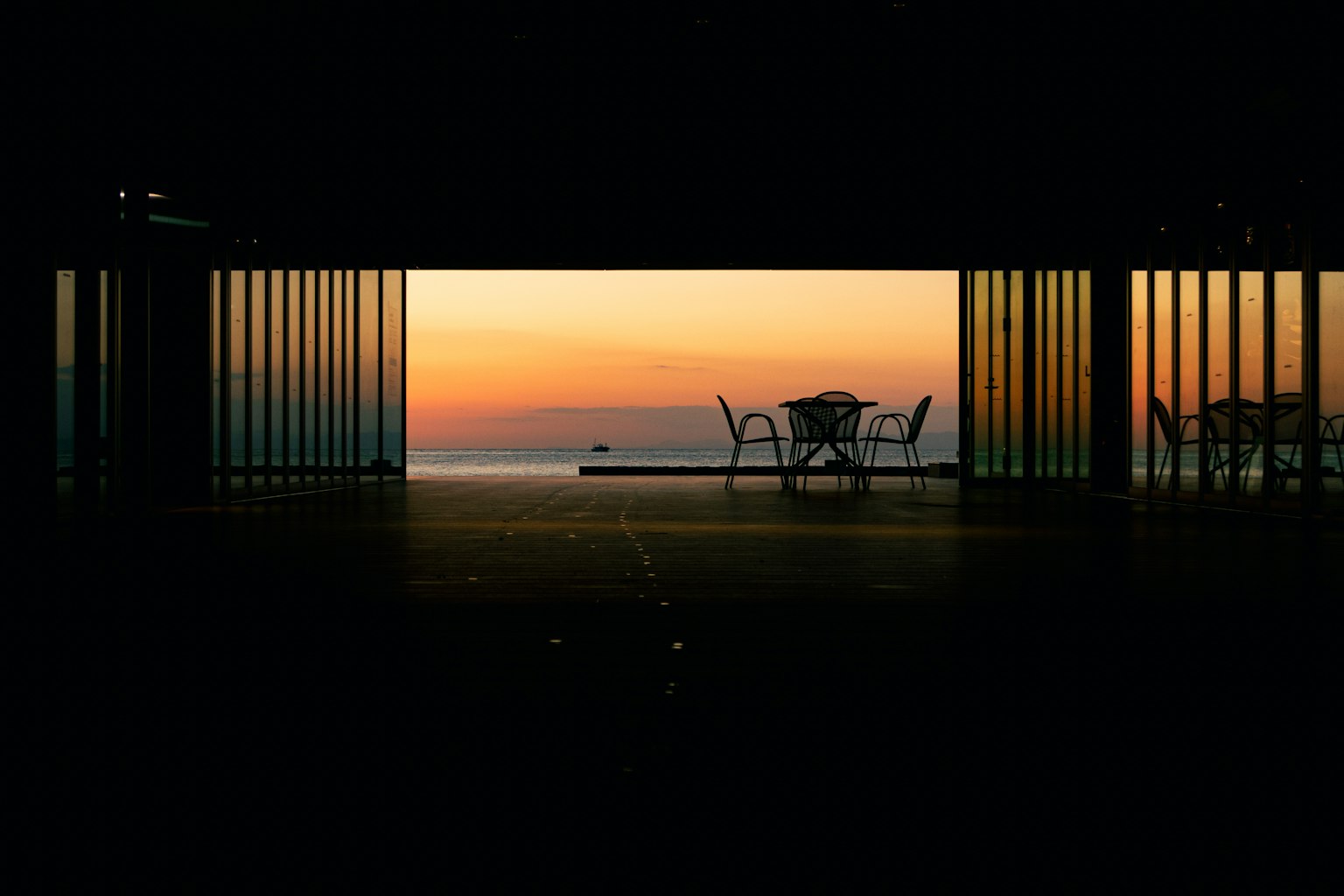 夕日が見えるガラスの窓からの景色 椅子とテーブルが見える