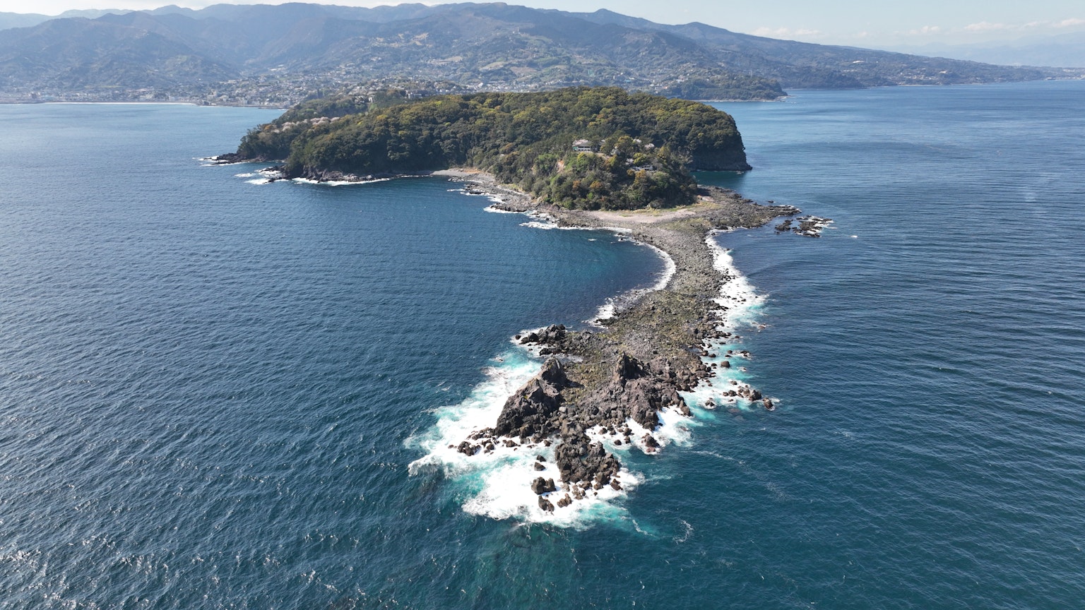 Una piccola isola circondata da un mare bellissimo con scogli
