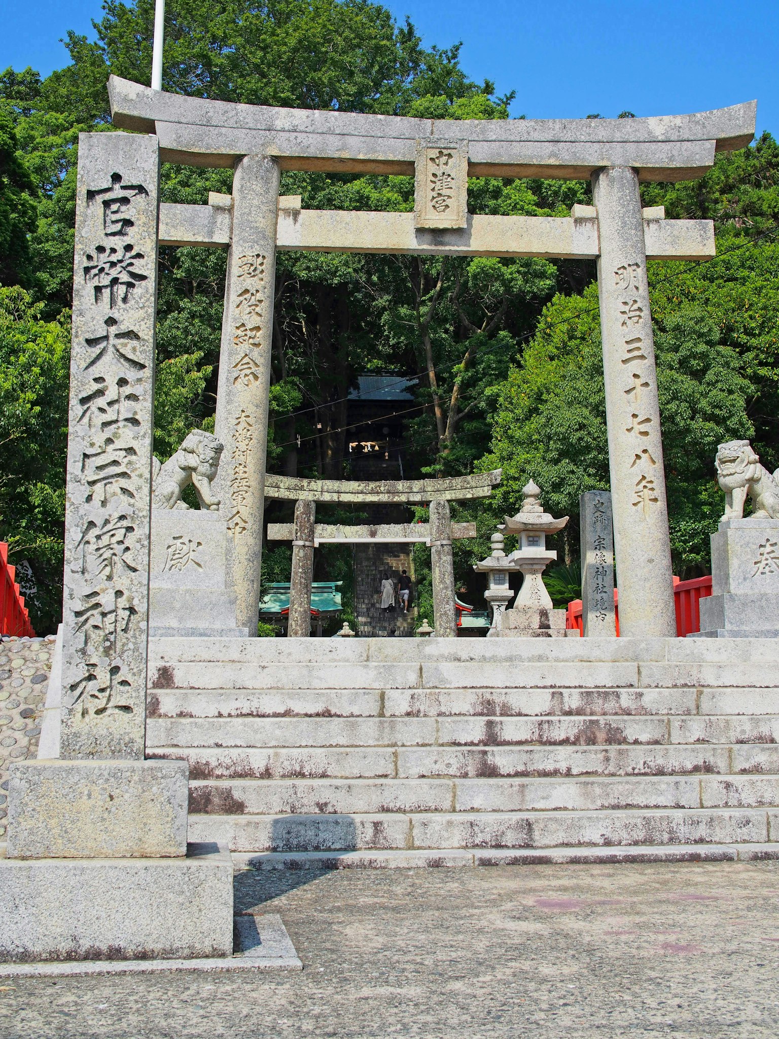石制鸟居和通往神社的台阶，四周环绕着树木