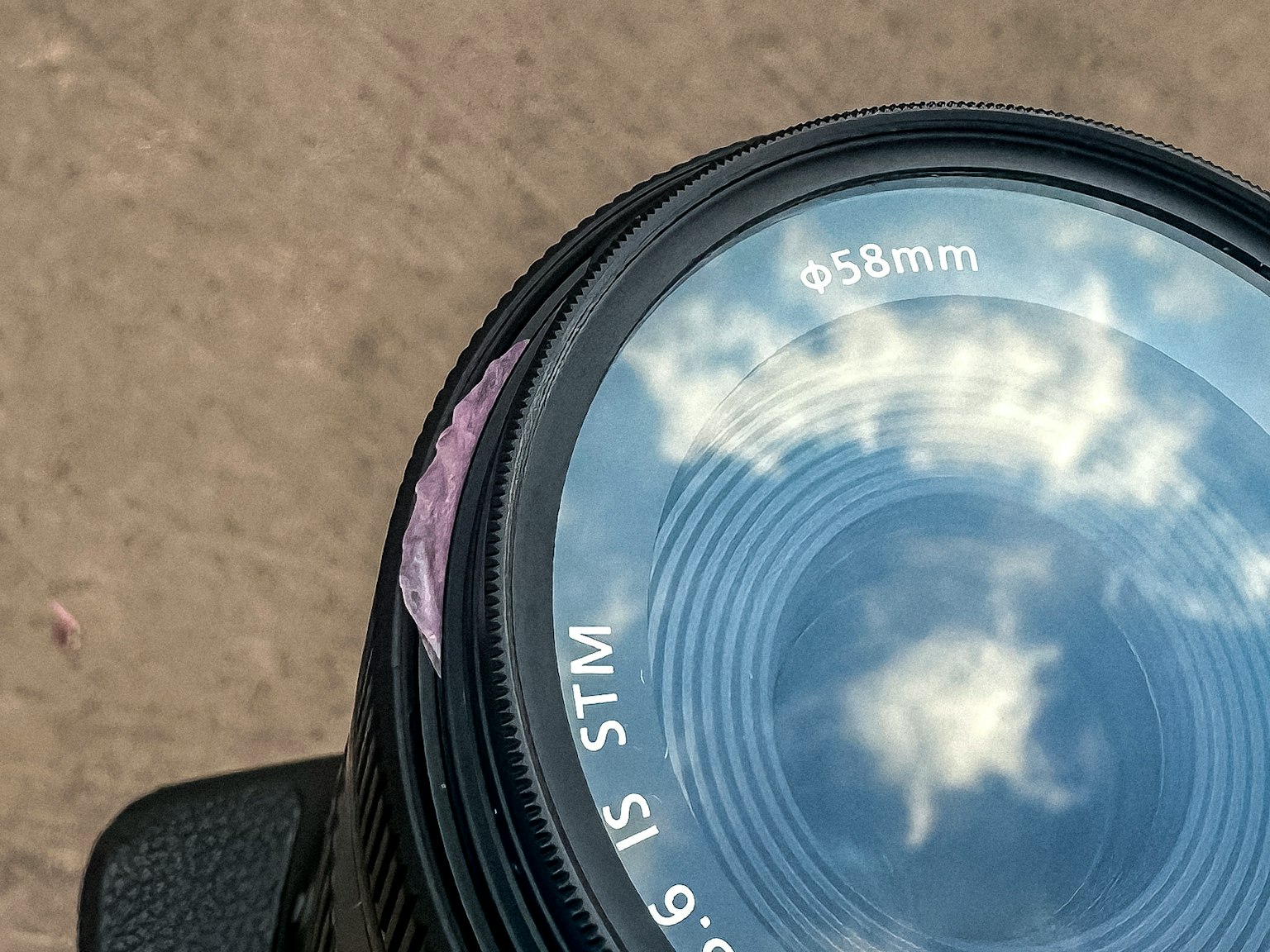 Objectif d'appareil photo reflétant des nuages dans le ciel
