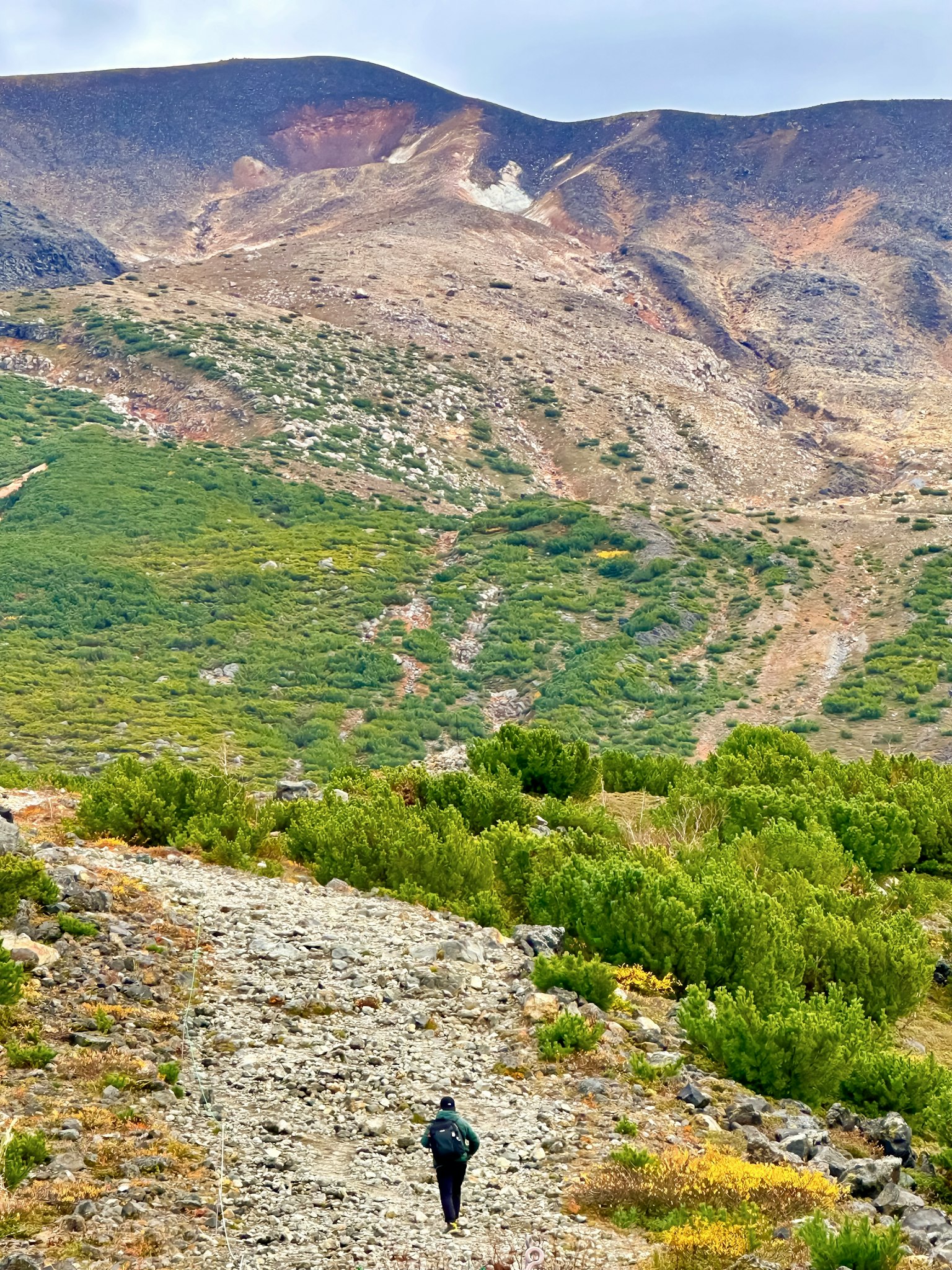 Persona che cammina su un sentiero roccioso con paesaggio montano