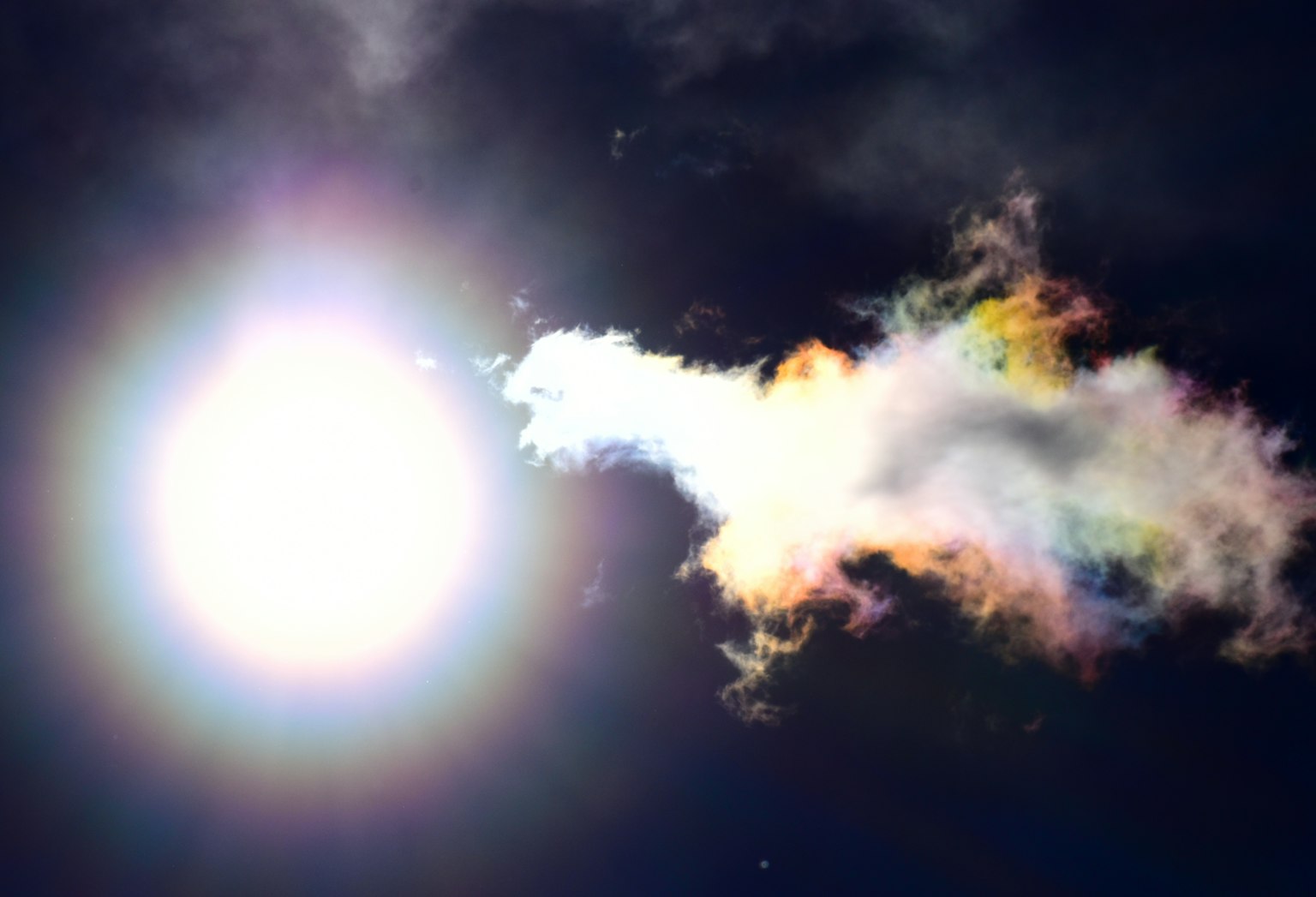 Sole luminoso con formazione nuvolosa colorata nelle vicinanze