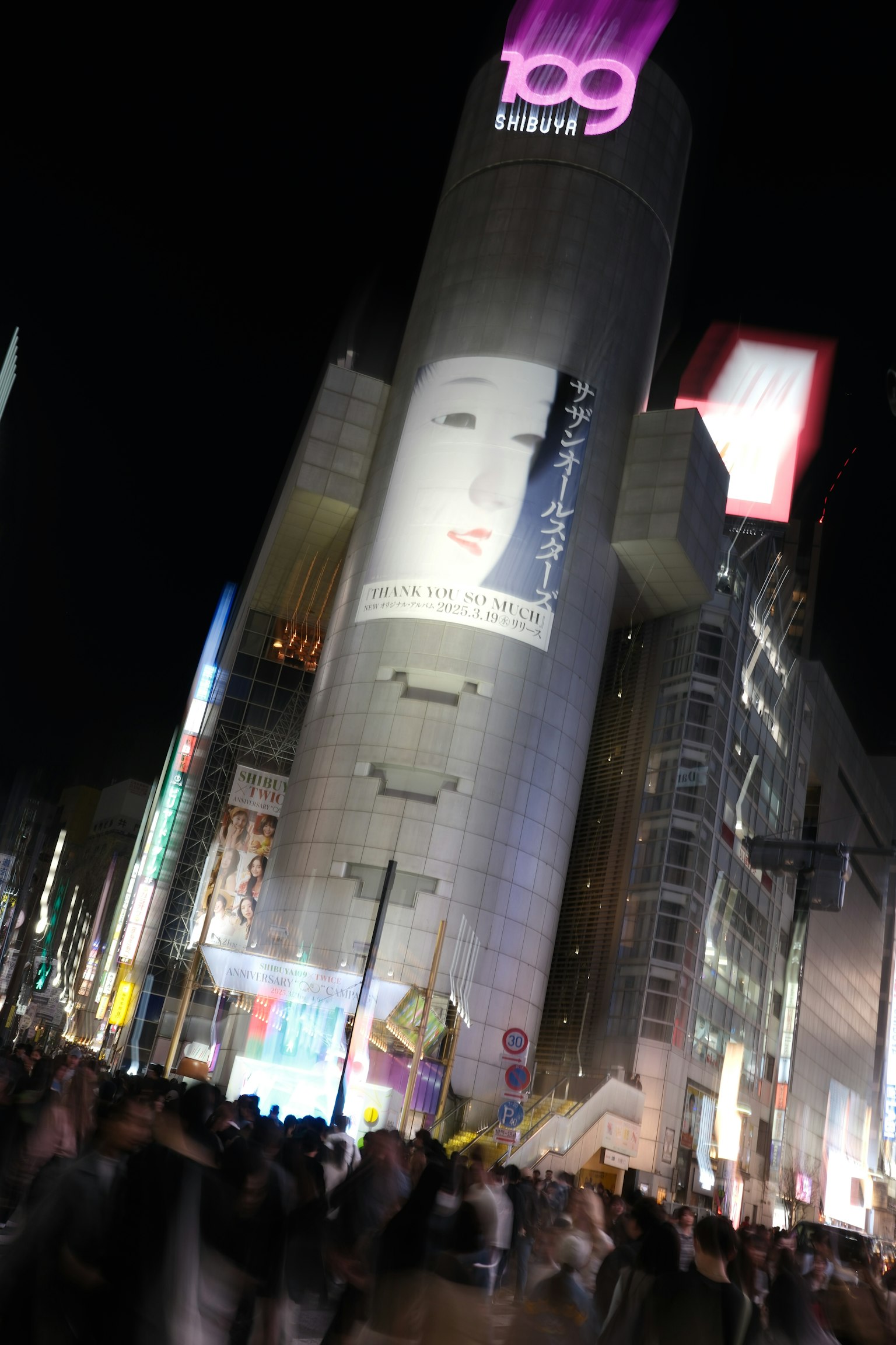 Vista notturna di Shibuya 109 con folle e pubblicità luminose
