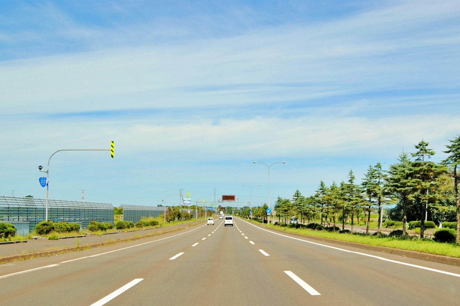Une route pittoresque avec un ciel bleu et des arbres verts sur les côtés