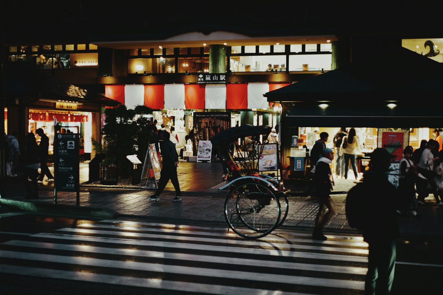 夜の街並みに人々が行き交う風景 自転車と横断歩道が見える