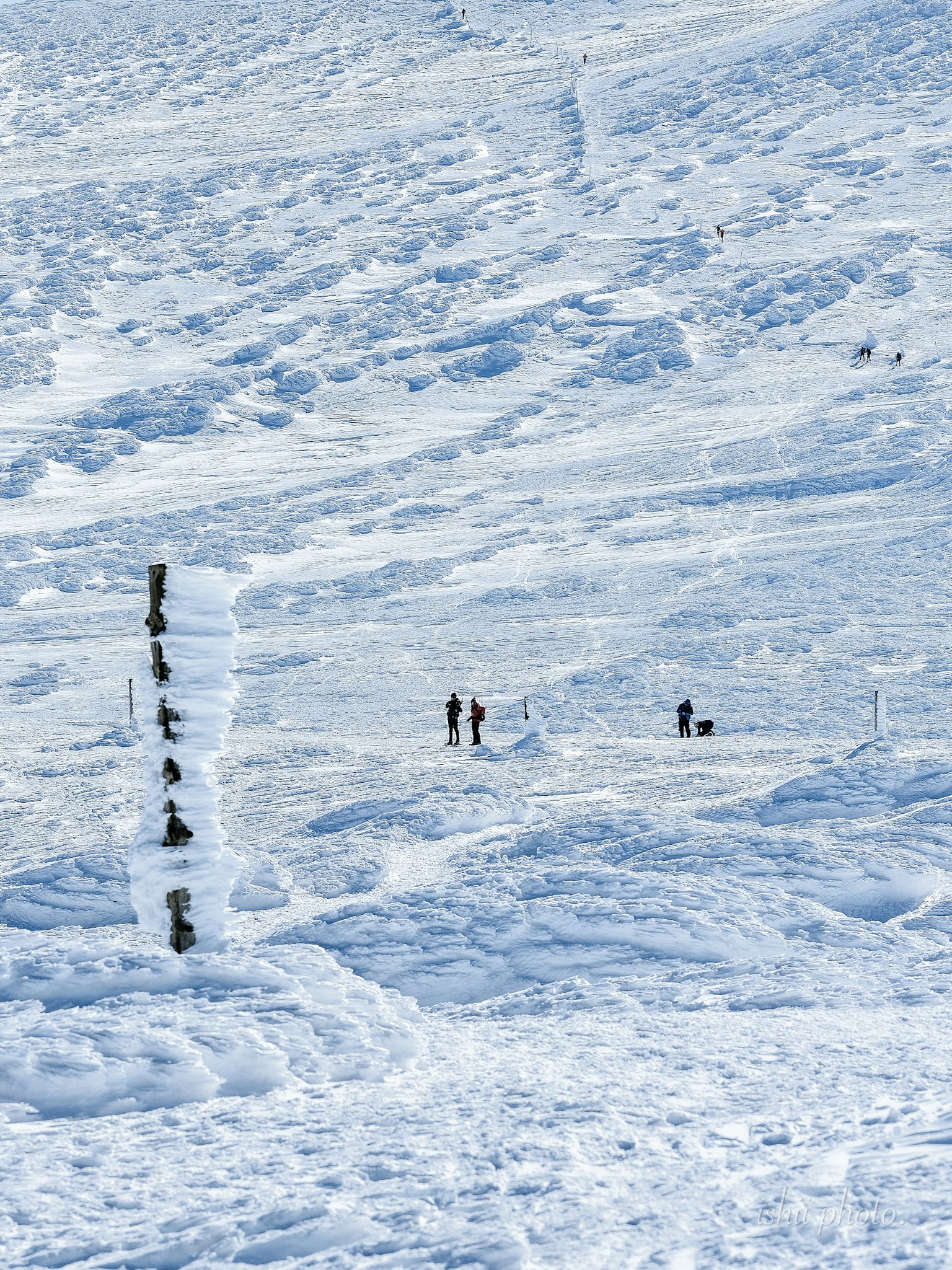 Paesaggio innevato con piccole figure che camminano