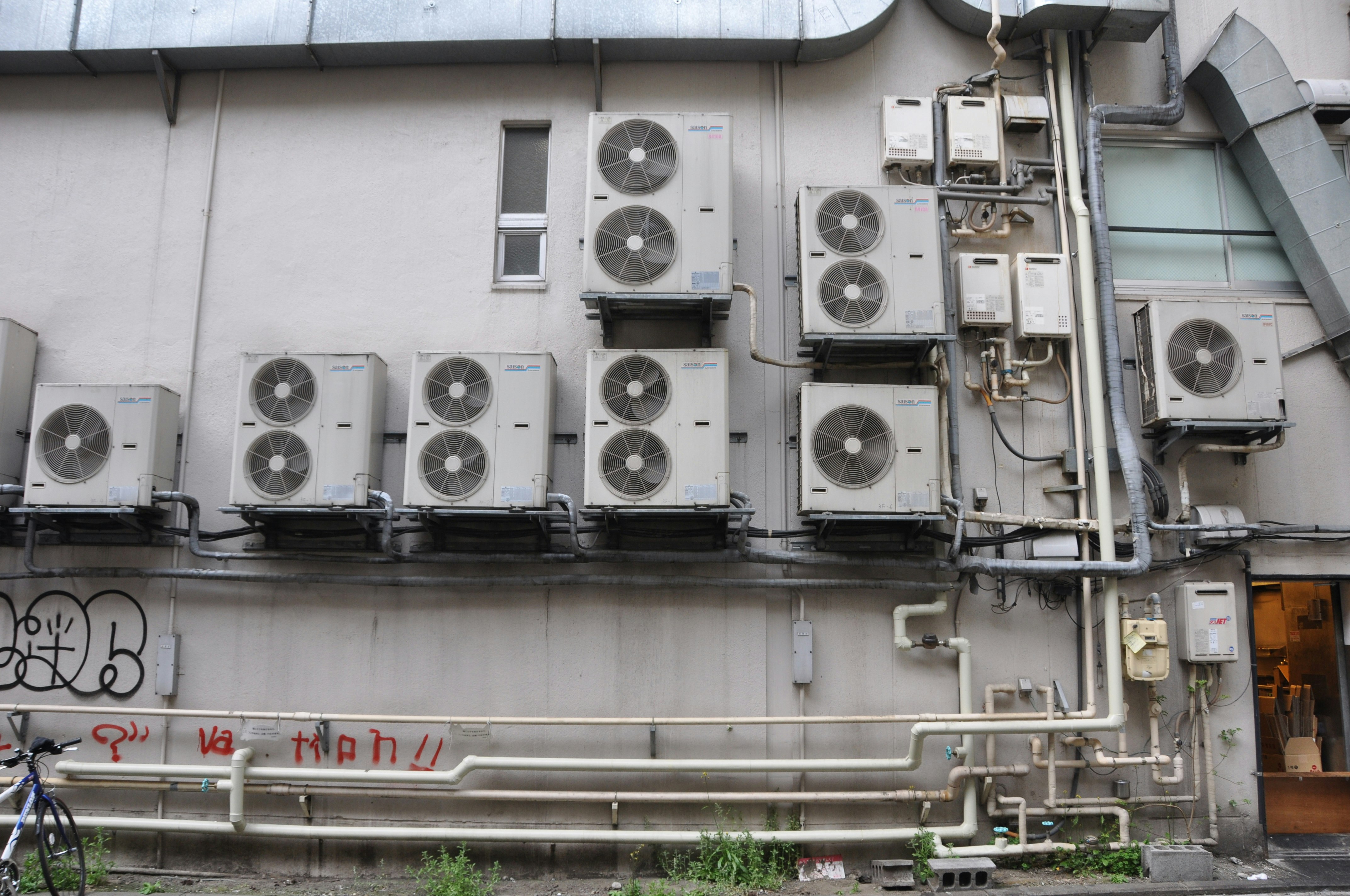 建築外牆上成排的冷氣室外機與管線
