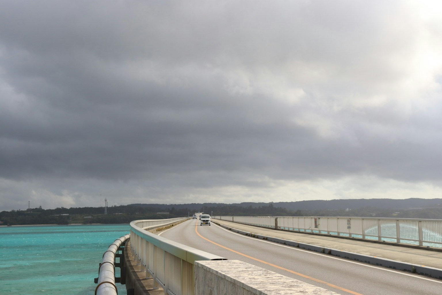 Vista escénica de un puente sobre agua turquesa con nubes oscuras