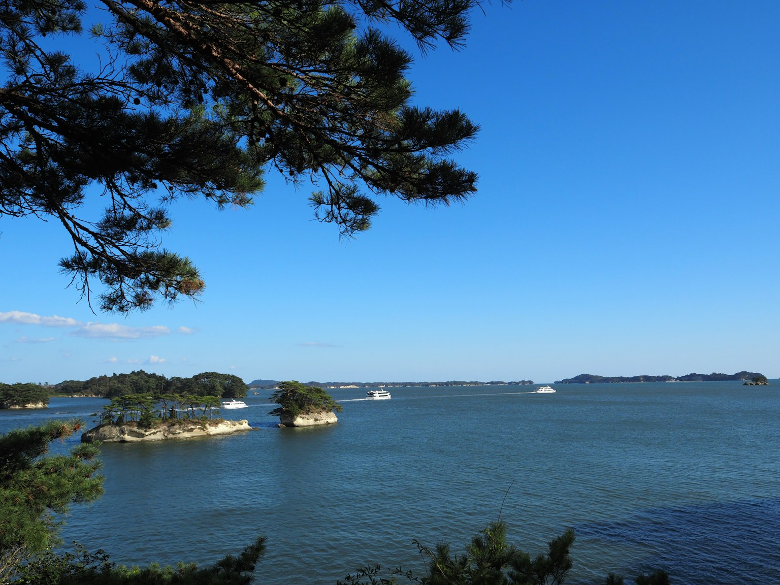 Scenic view of small islands on blue water under a clear sky