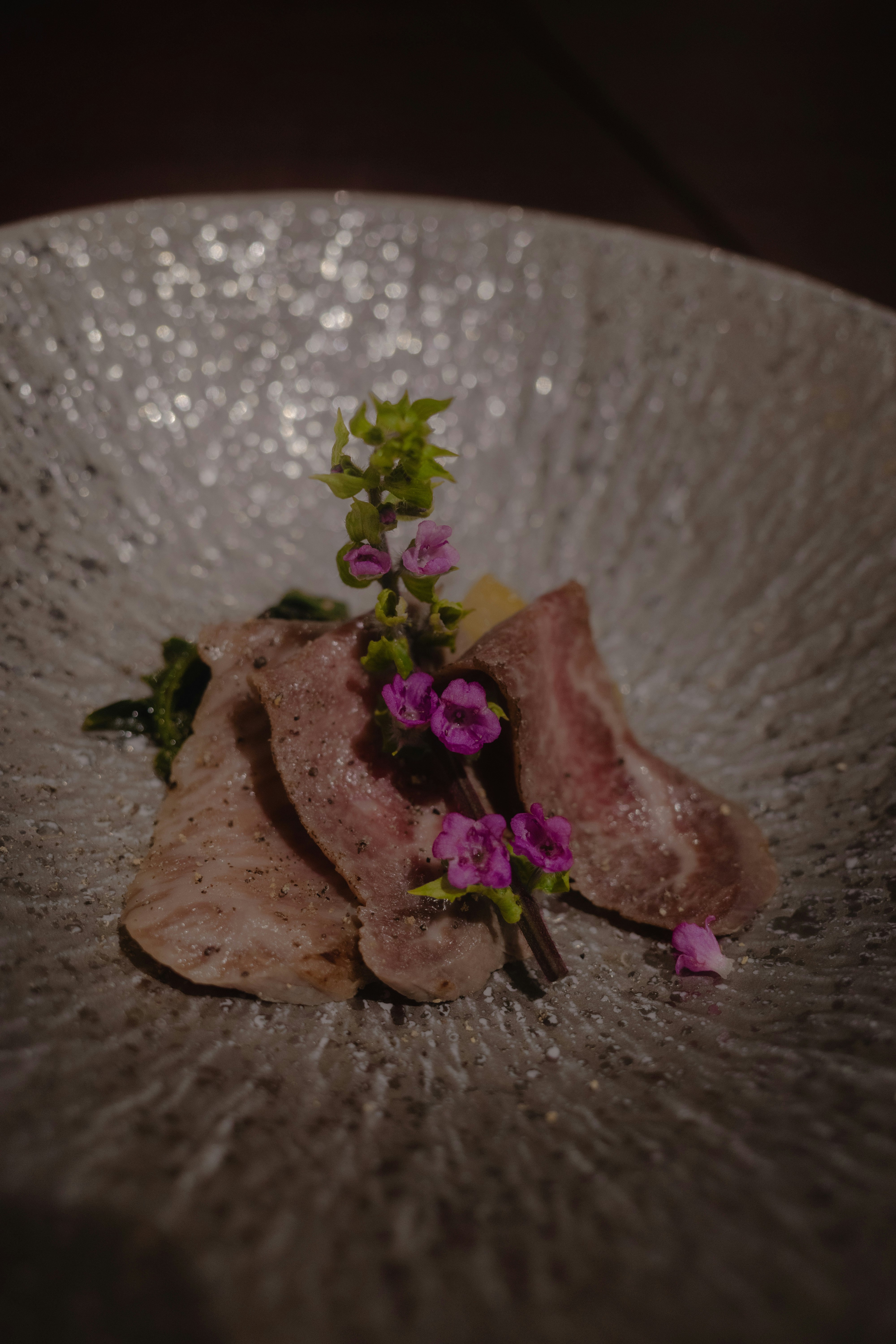 擺盤的肉類菜餚，點綴花朵與香草