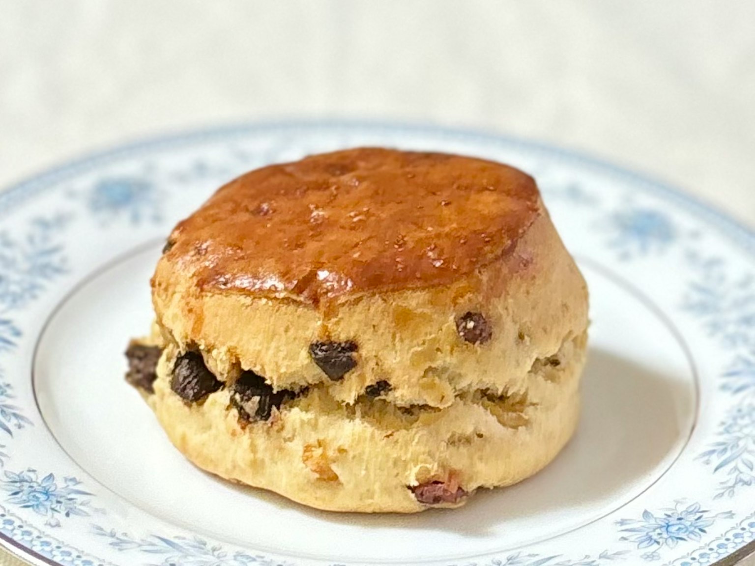 A delicious scone placed on a blue floral patterned plate