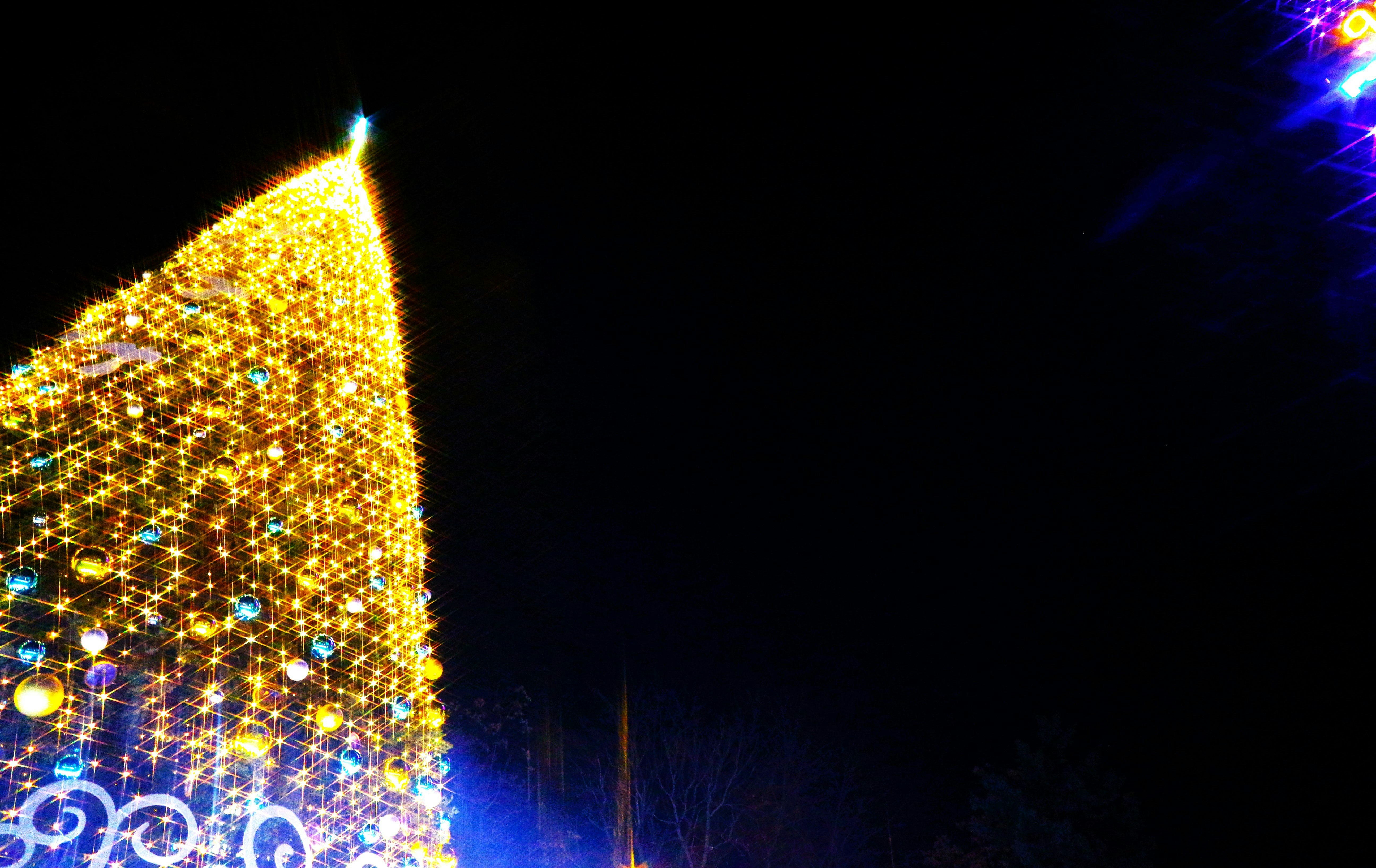 A glowing Christmas light display with a luminous arch against the night sky