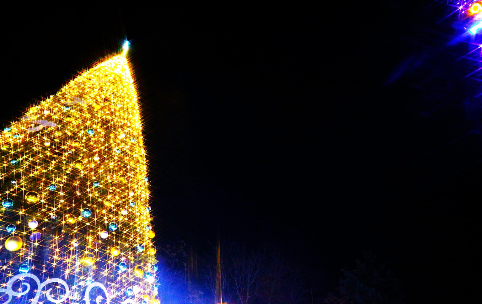 Árbol de Navidad iluminado brillando en el cielo nocturno