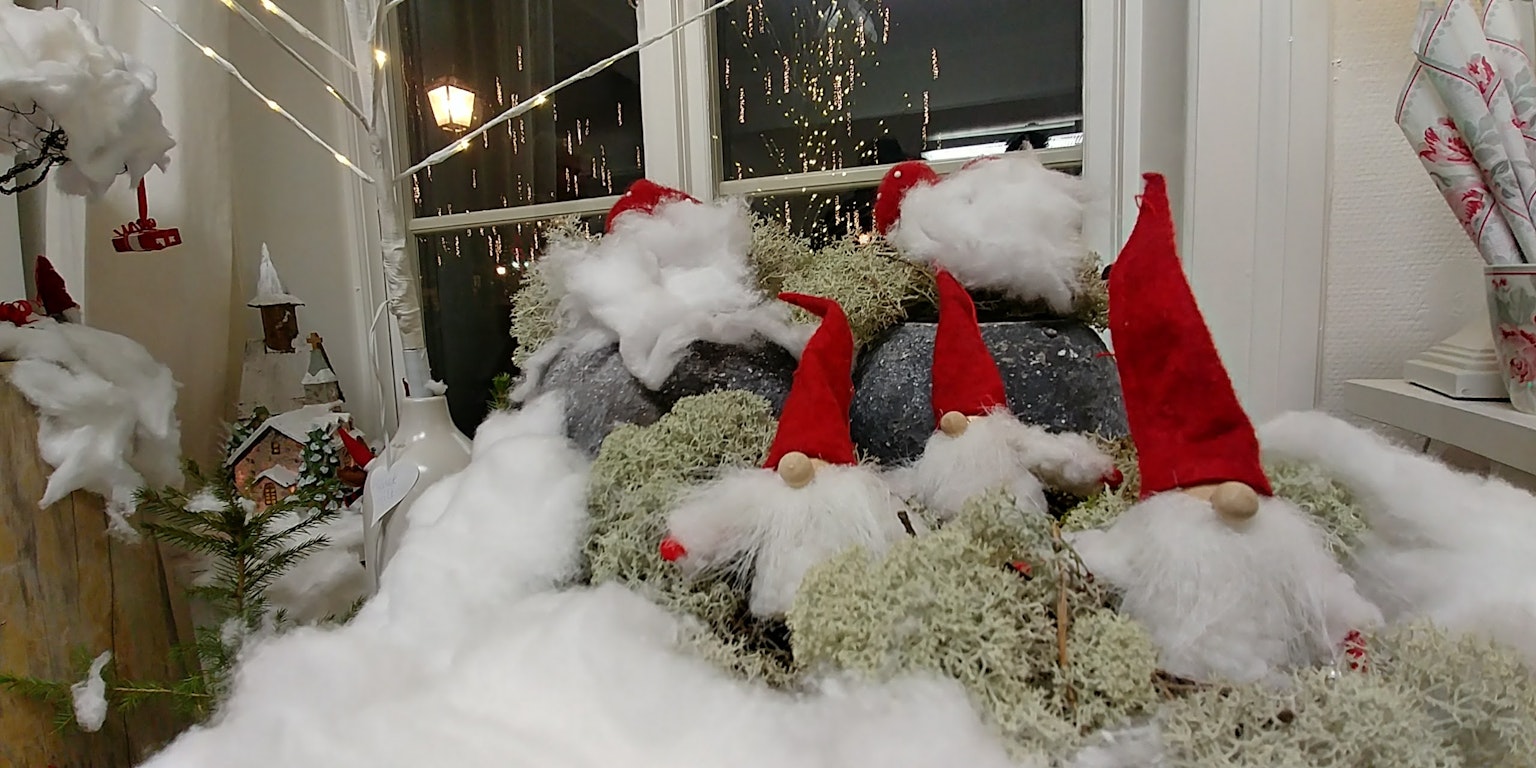 Small figurines with red hats hidden in snow for winter decoration