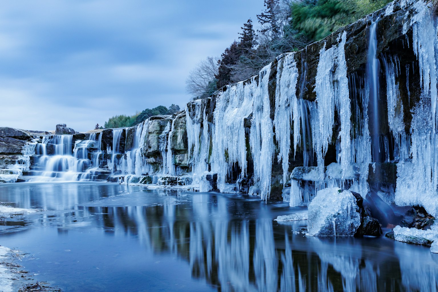 Frozen waterfall with icy formations and blue reflections