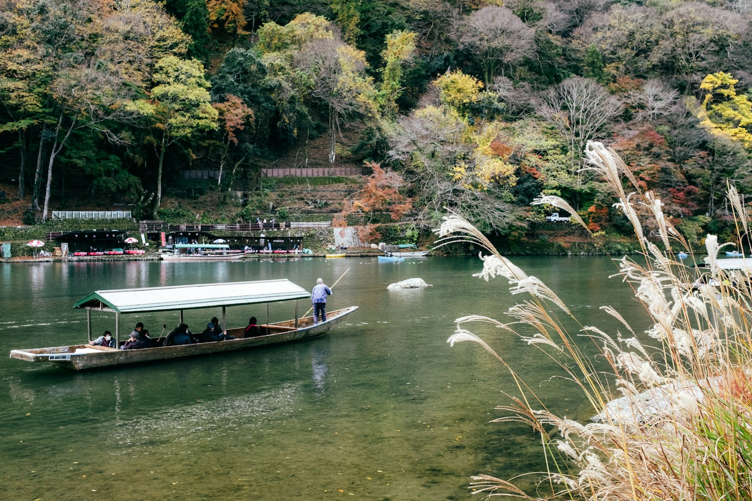 Una scena di fiume serena con una barca tra il fogliame autunnale