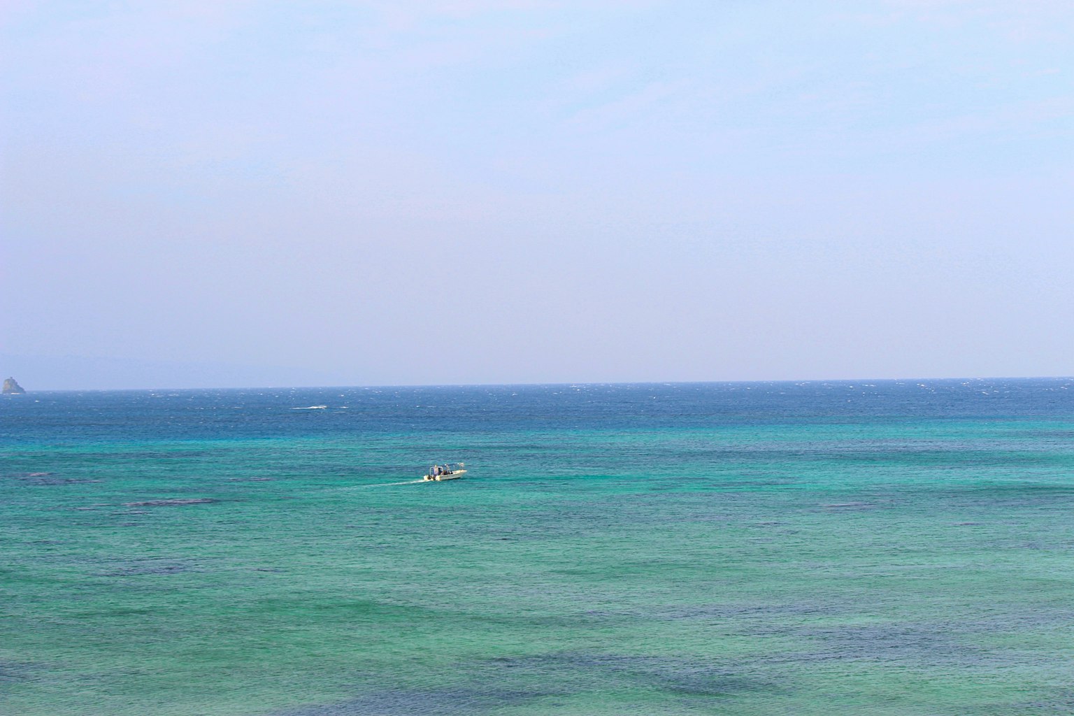 蓝色海洋的风景，远处有一只小船
