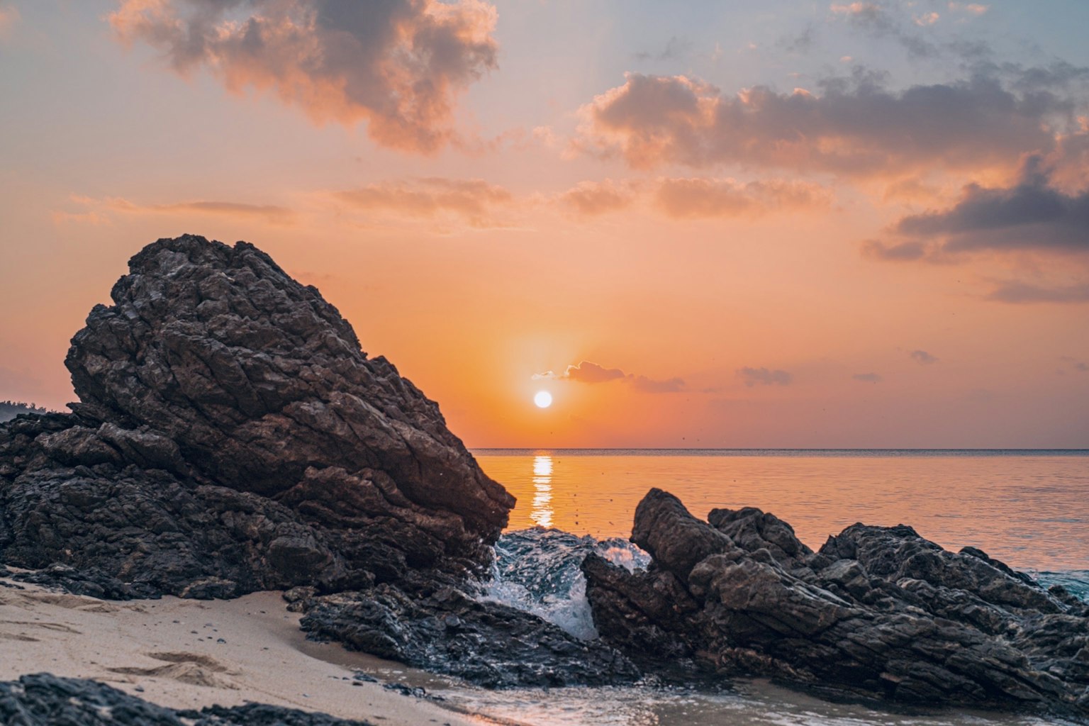 Beautiful sunset over the ocean with rocks in the foreground