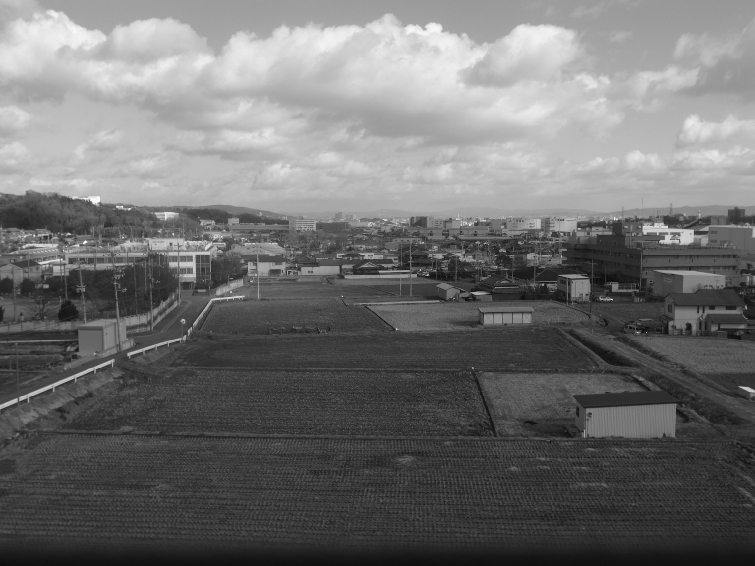 Schwarz-weiß Stadtansicht mit weitem Himmel und Wolken