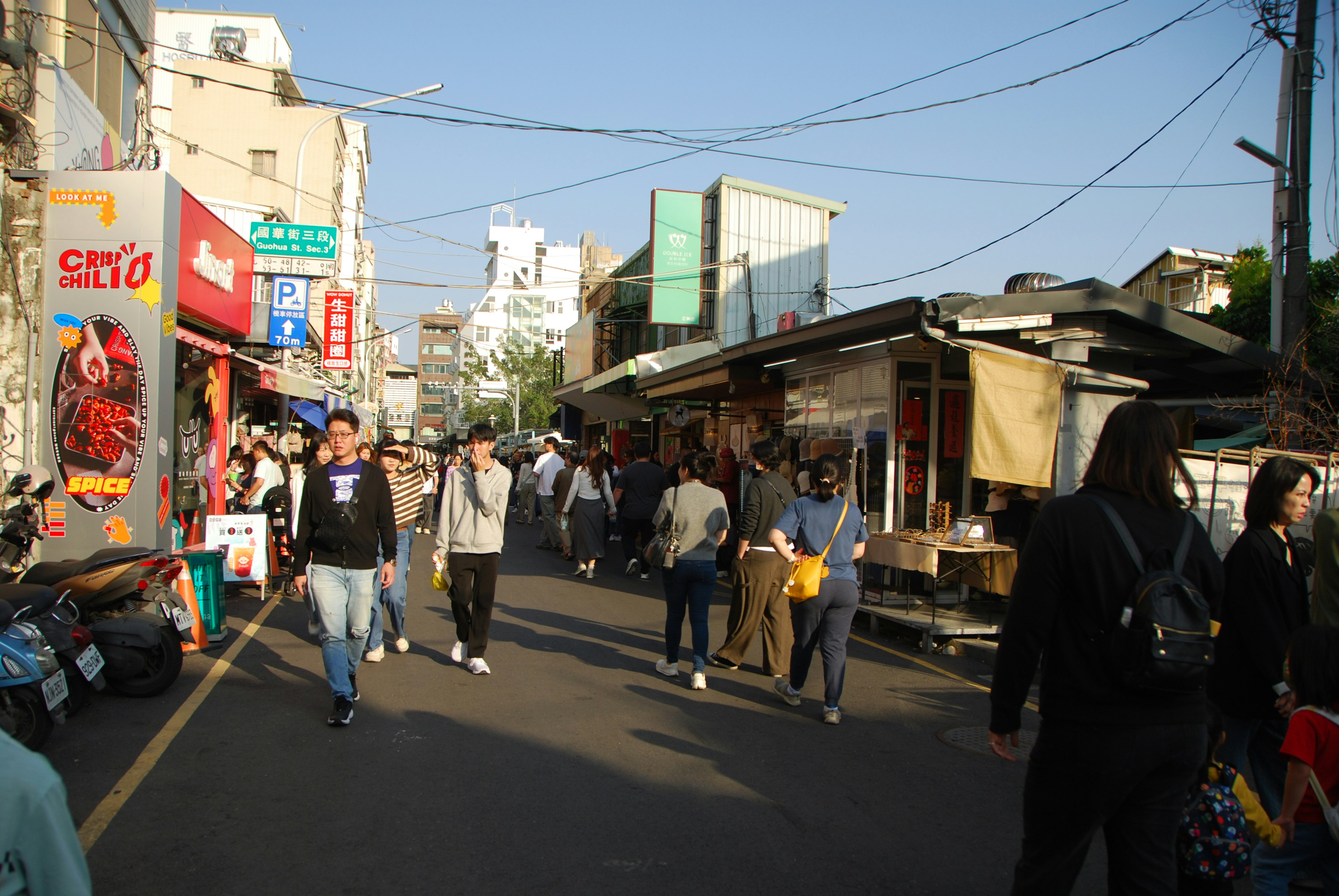商店街の軒先に並ぶ屋台と人通りのある路地
