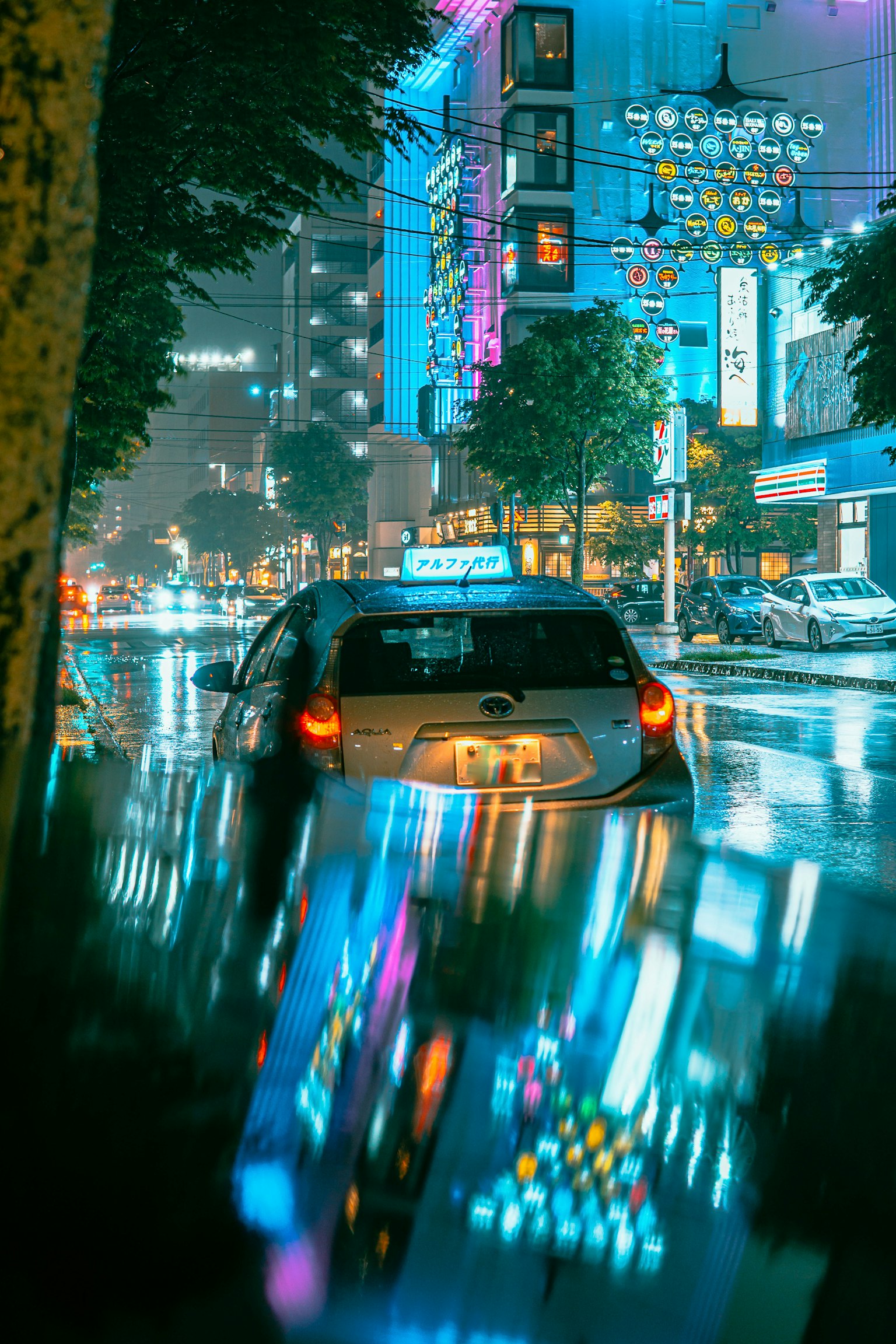Scena urbana notturna con luci al neon e un'auto in una pozzanghera