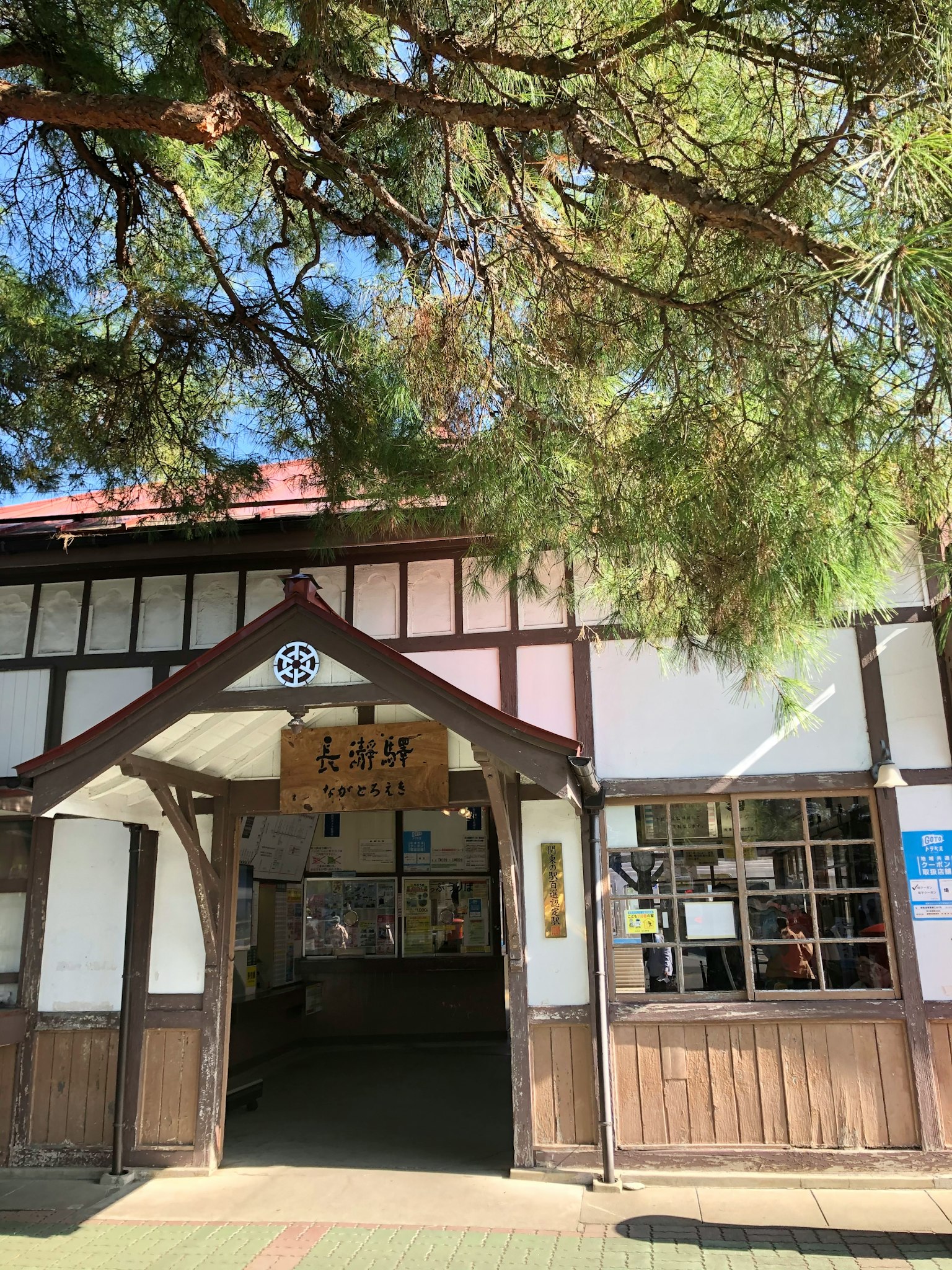 被树木环绕的传统日本建筑入口，展示独特的建筑特征