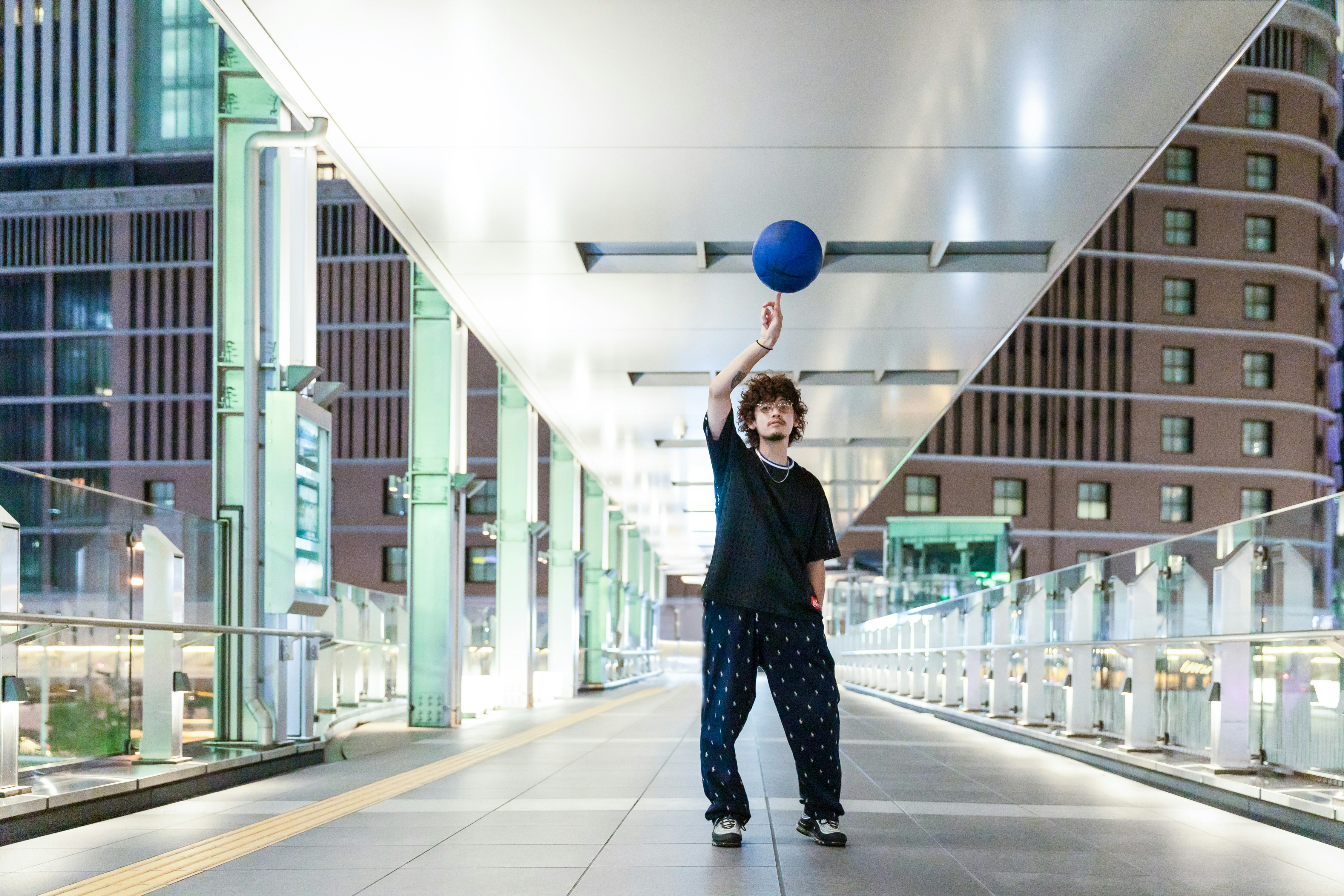 高層ビル街の回廊でポーズをとる人物