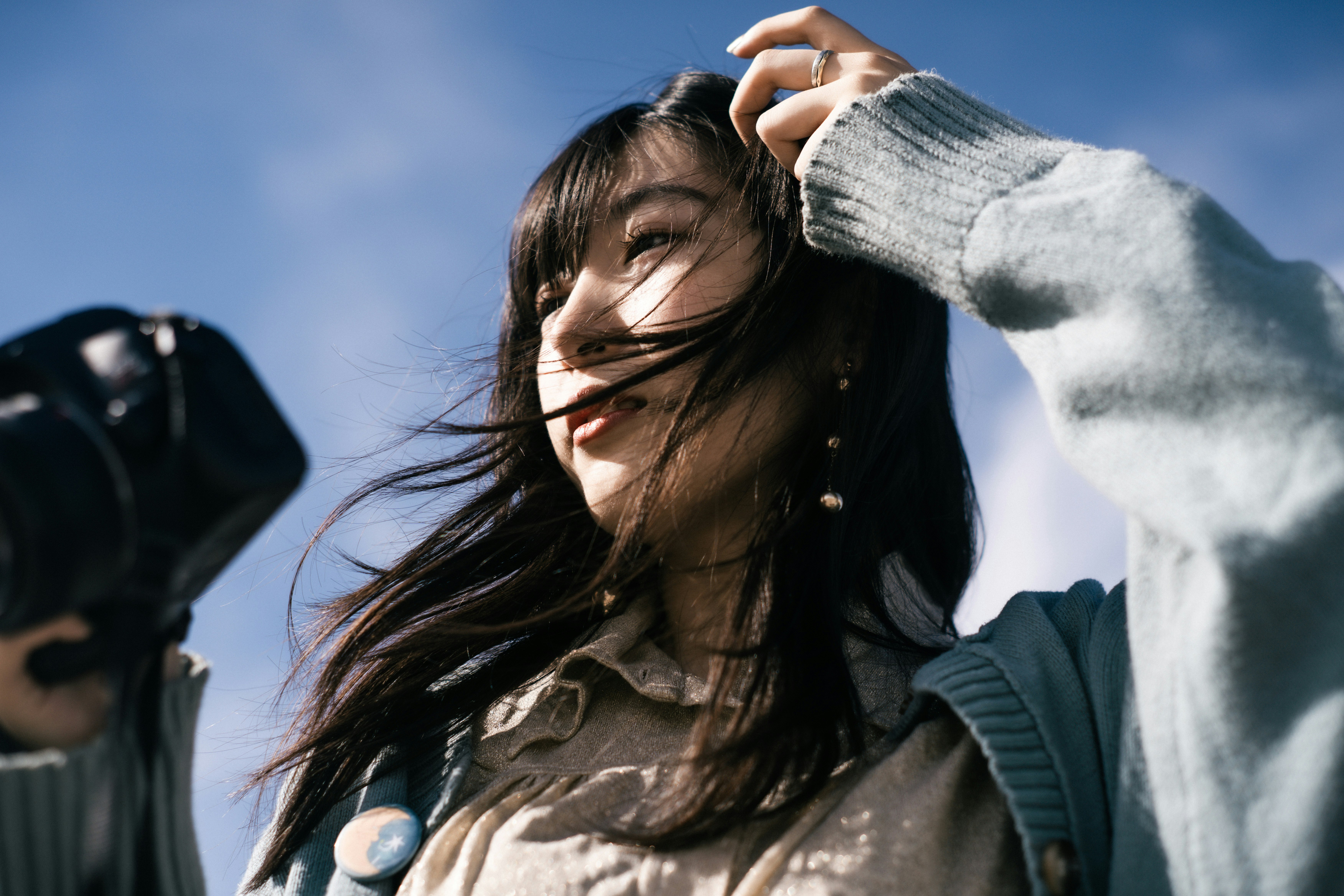戶外瞬間：長髮隨風的女性抬頭凝視
